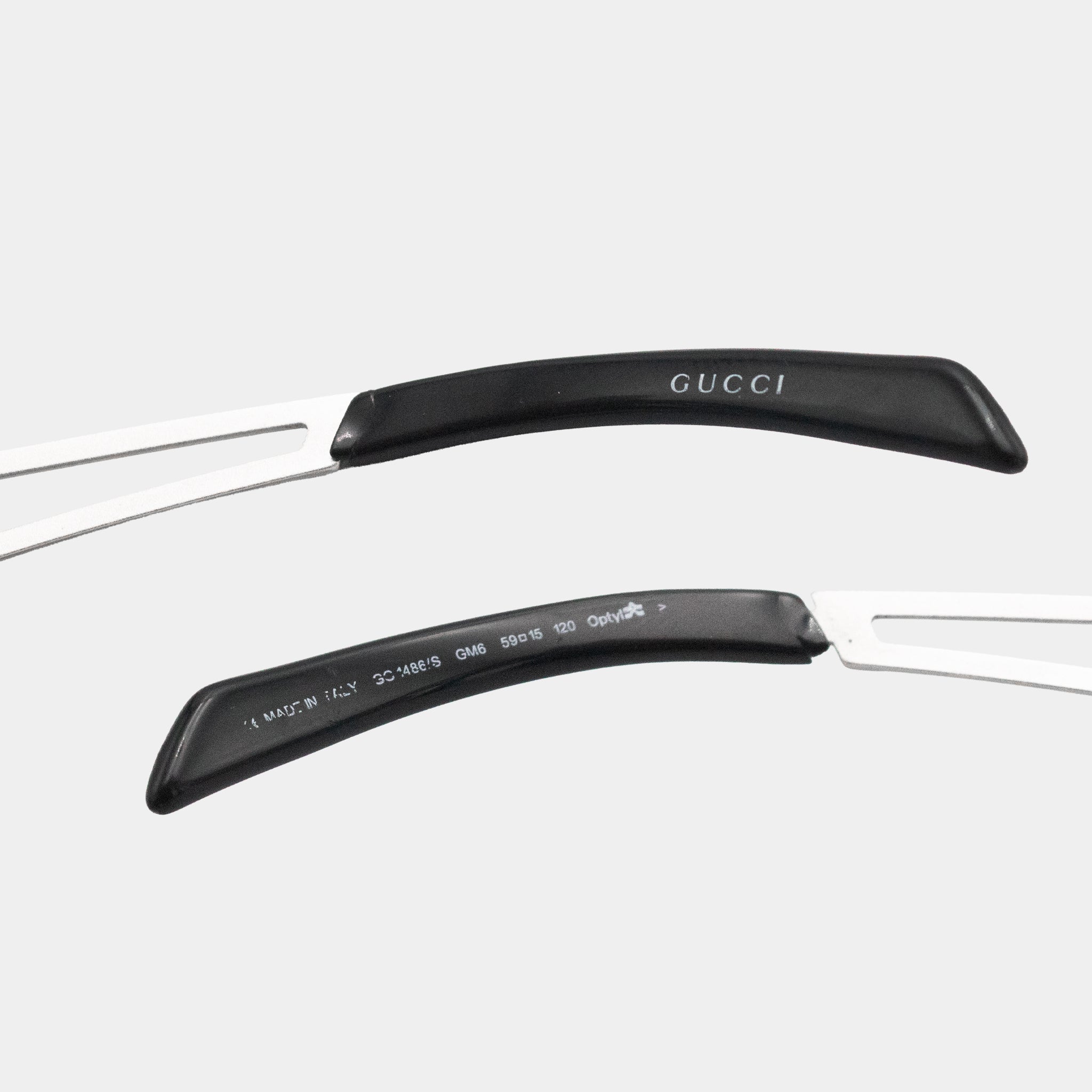 a pair of Gucci sunglasses with black handles and a white frame.