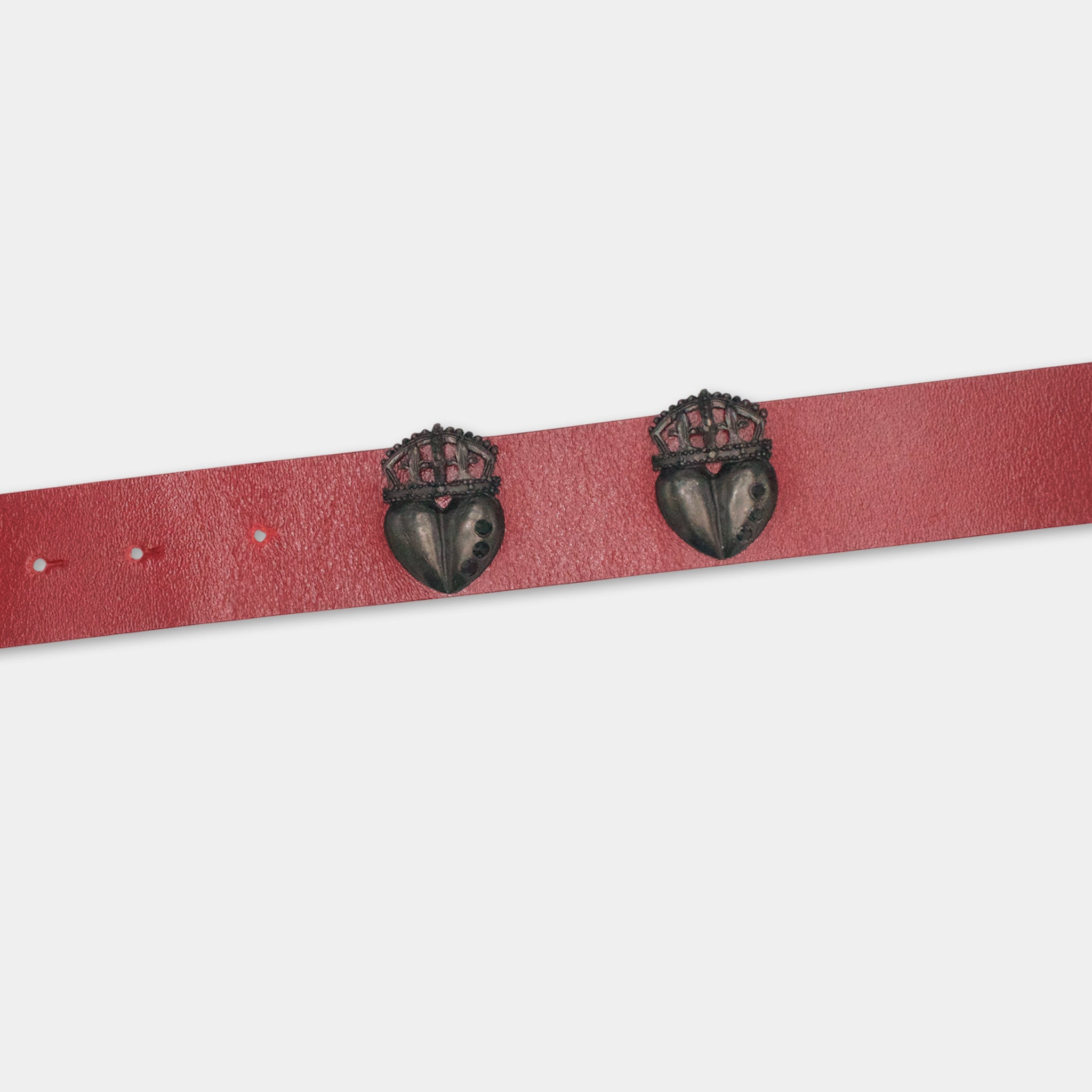 A red belt with two black heart-shaped charms or pendants attached to it.