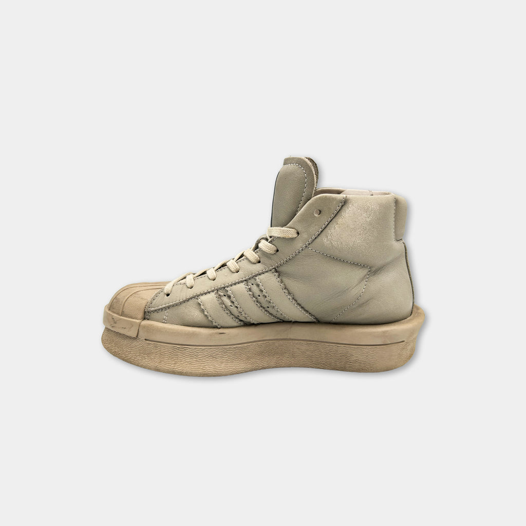 A tan Adidas sneaker with a platform sole and a high top, featuring the Adidas logo.