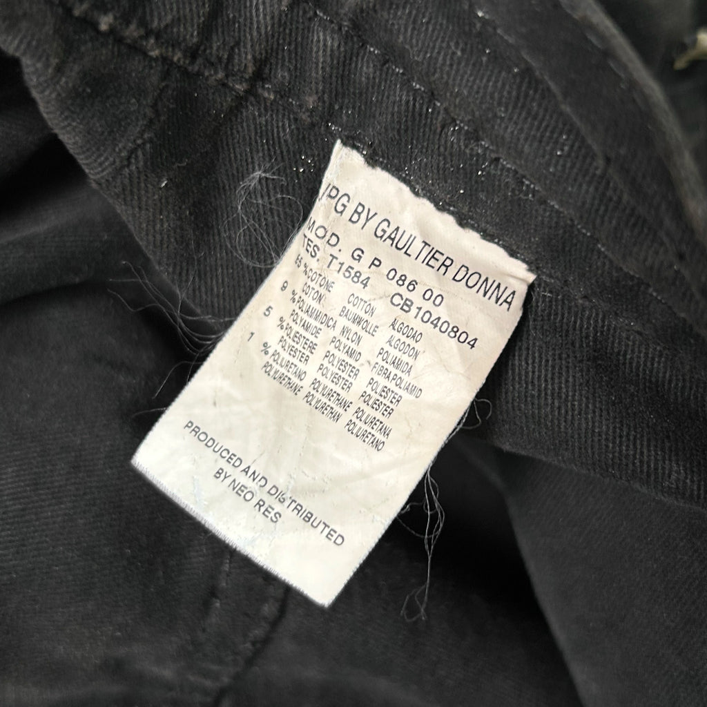 a close-up view of a black fabric, possibly a piece of clothing, with a label attached to it. The label contains text and numbers, but the image does not contain any text that can be described in fewer than 500 characters.