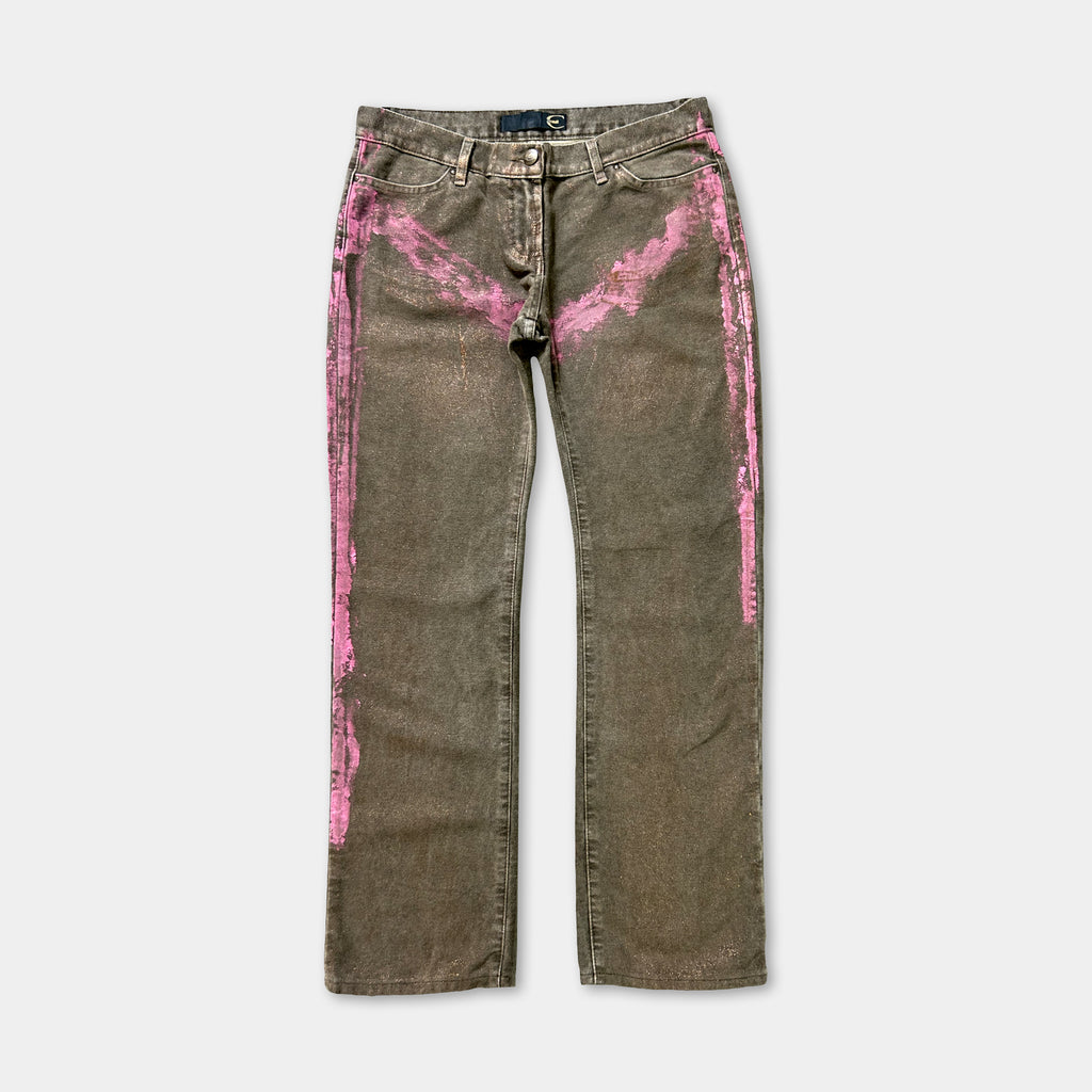 A pair of dark green jeans with pink streaks on the sides.
