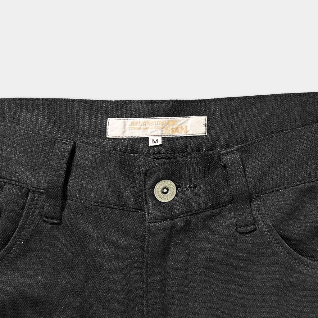 A pair of black pants with a label on the waistband.