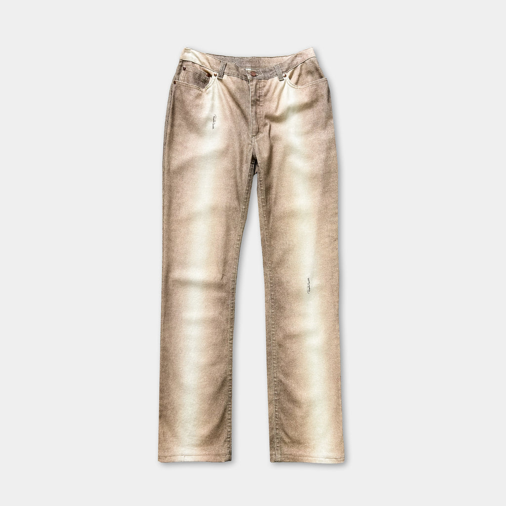 A pair of tan-colored jeans with visible wear and tear, including holes in the knees.