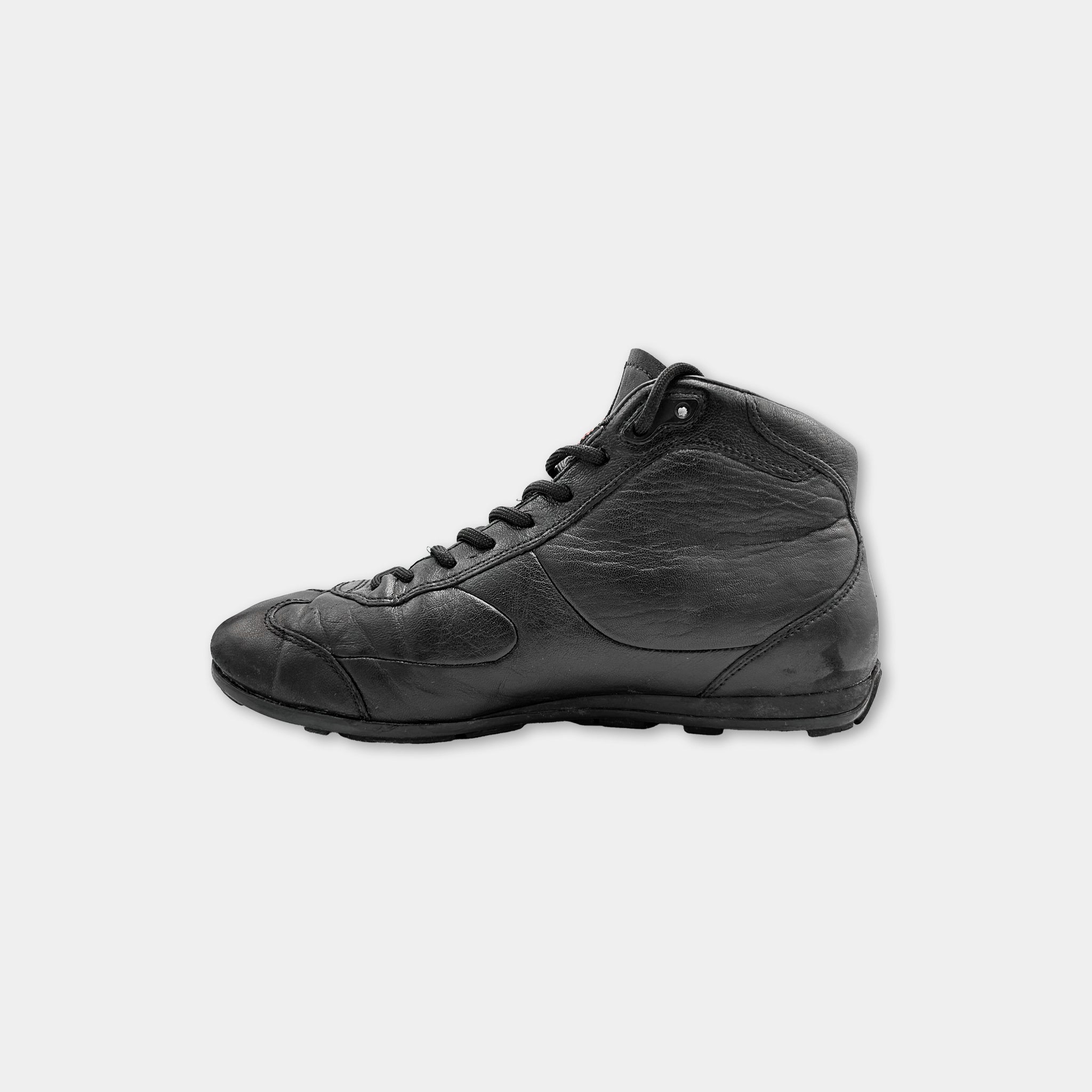 A black leather sneaker with a lace-up design and a rugged sole.