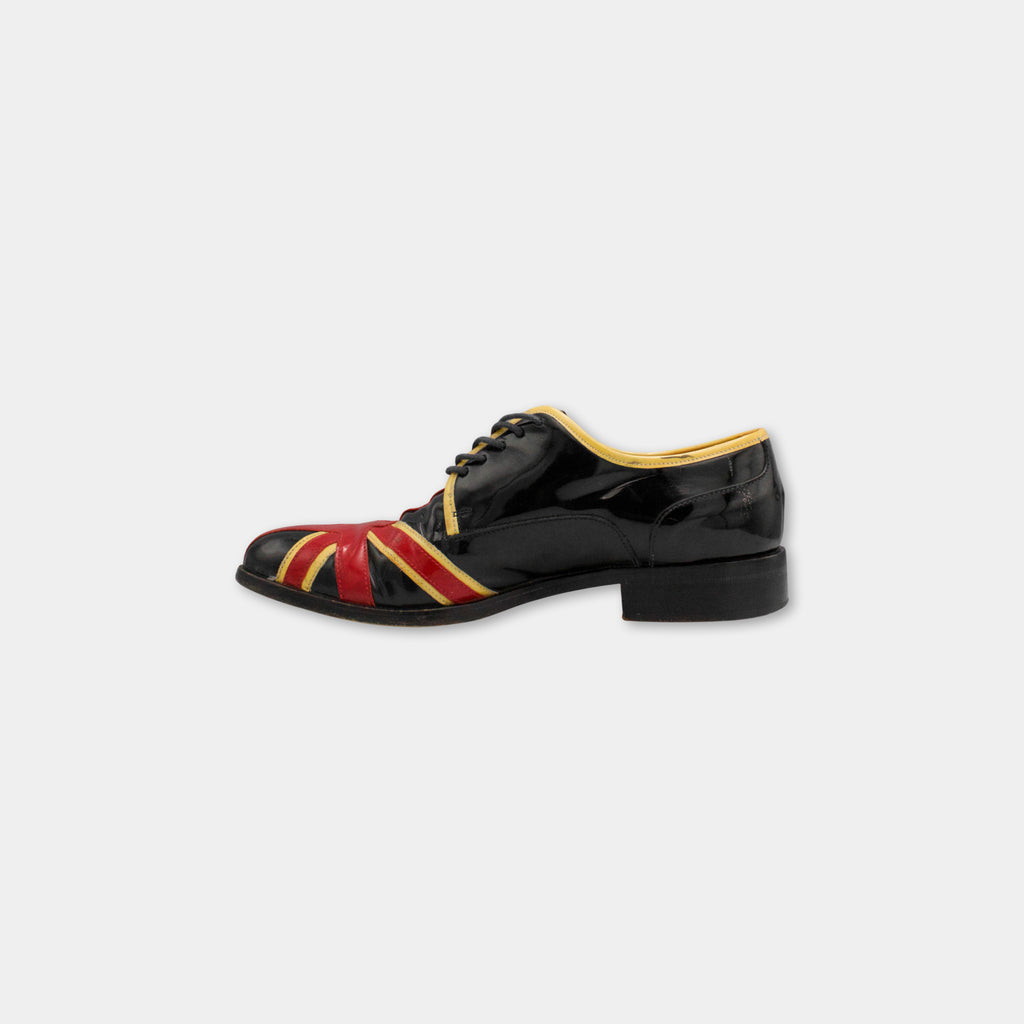 A black and red shoe with a yellow trim, featuring a Union Jack design on the side.