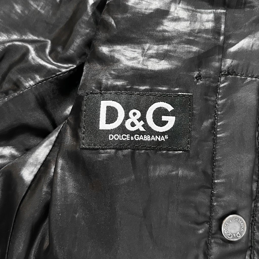 A close-up of a black leather jacket with a D&G logo on the left side.