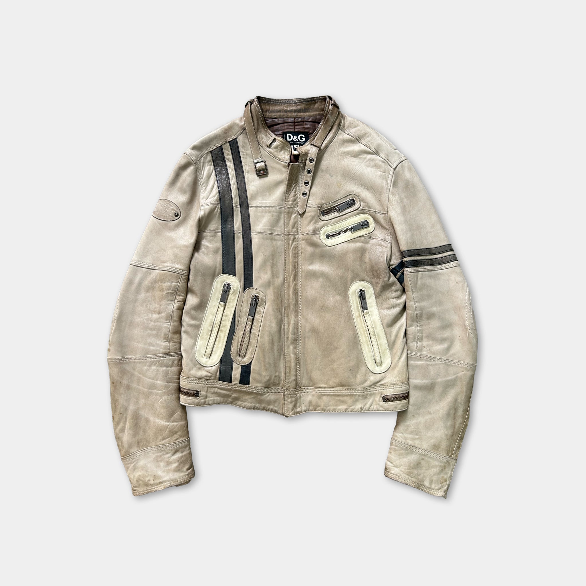 A tan leather jacket with black stripes and zippers, featuring a collar and multiple pockets.