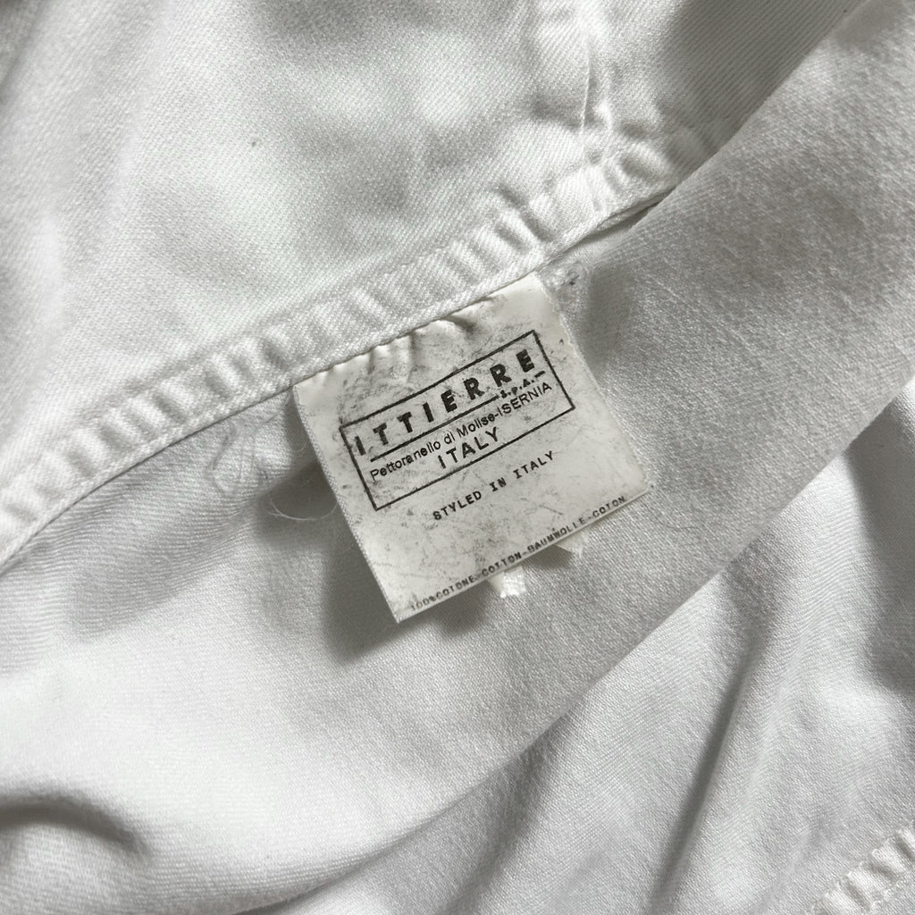 a close-up view of a white fabric, possibly a piece of clothing, with a label attached to it.
