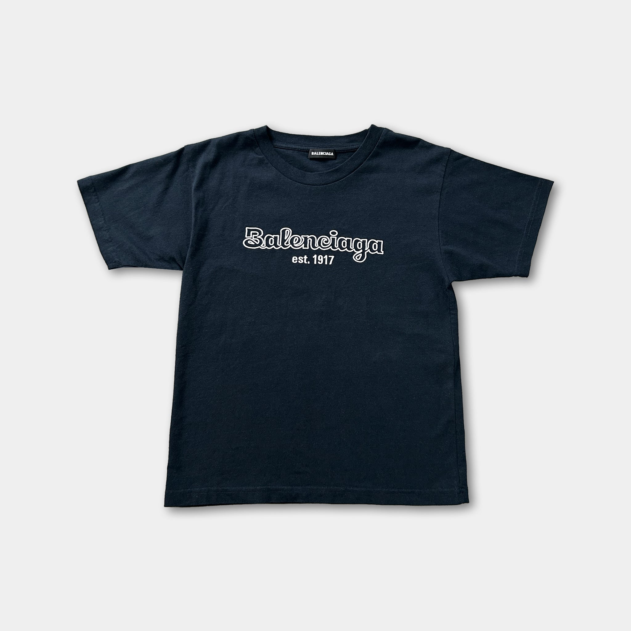 A navy blue t-shirt with the text "Balenciaga est. 1917" printed on it.