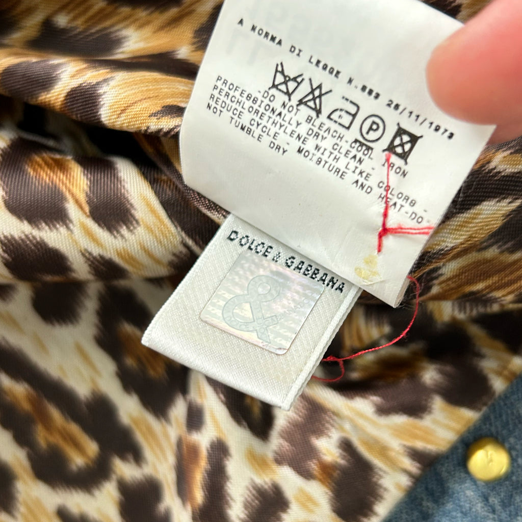 A close-up of a clothing label with a leopard print pattern, featuring a brand name and care instructions.
