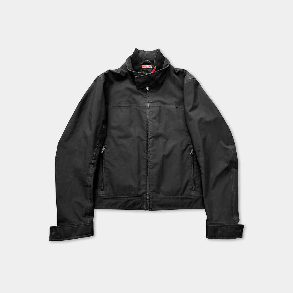 A black jacket with a high collar and zipper, displayed against a white background.