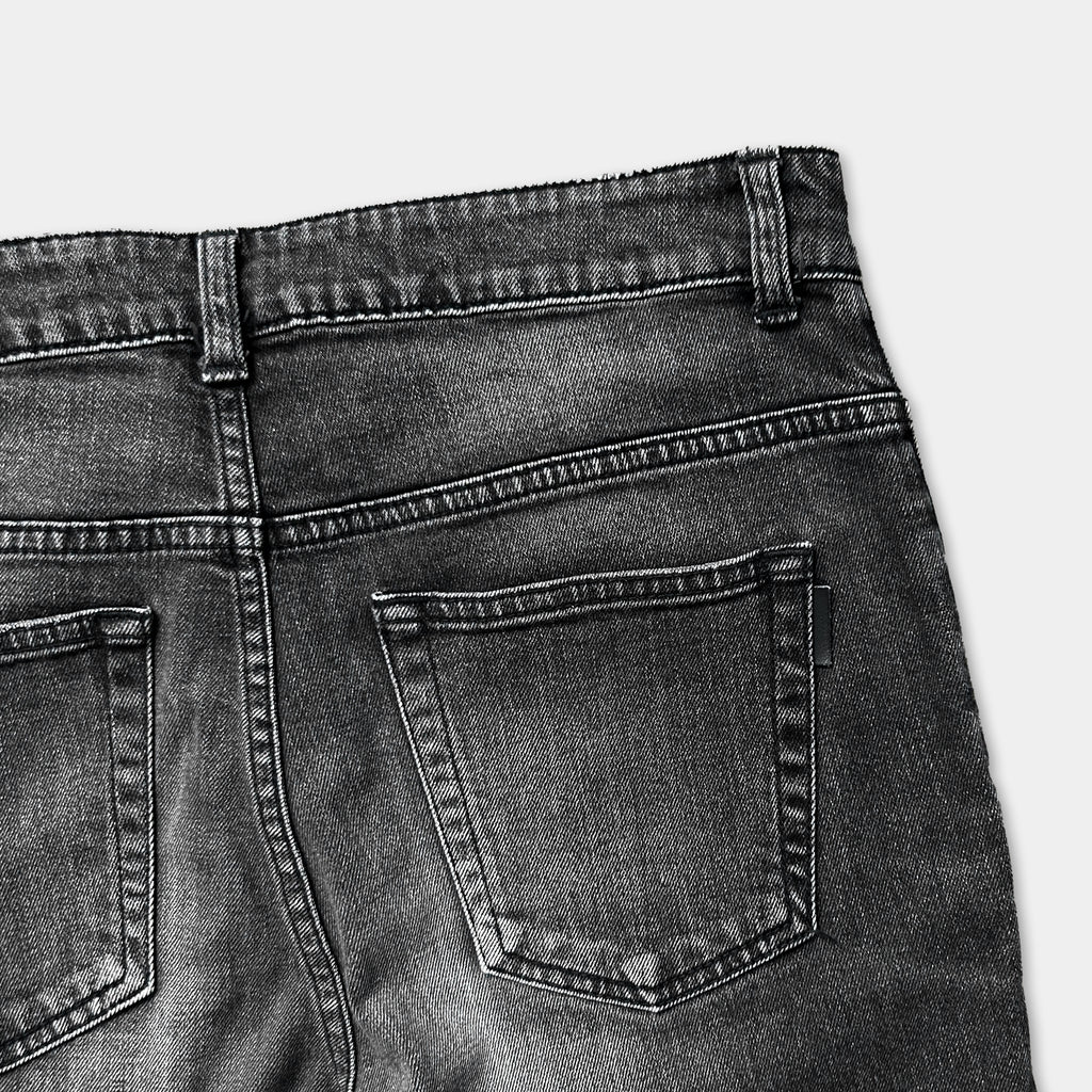 a close-up view of the back of a pair of black jeans, focusing on the pockets and the waistband.