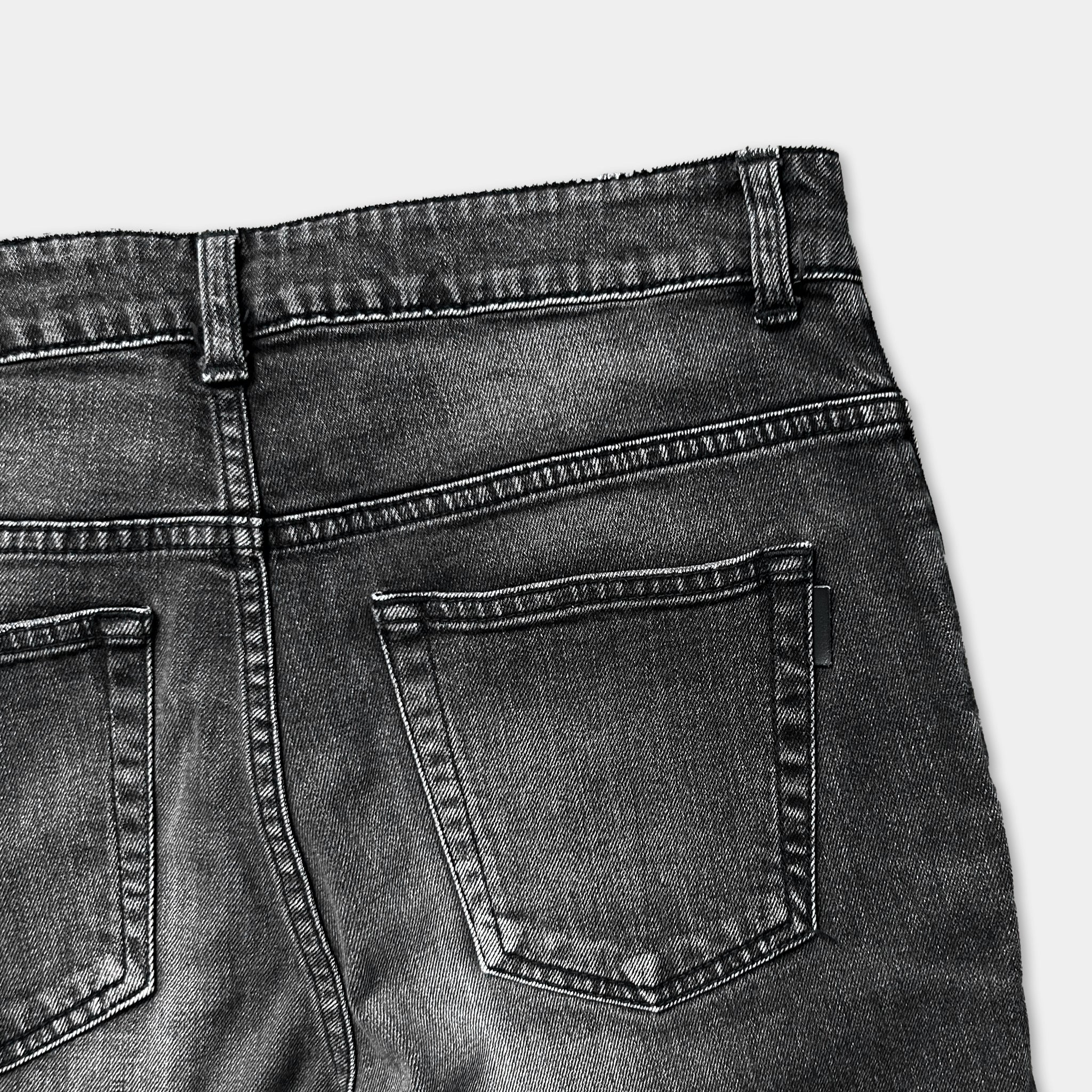 a close-up view of the back of a pair of black jeans, focusing on the pockets and the waistband.