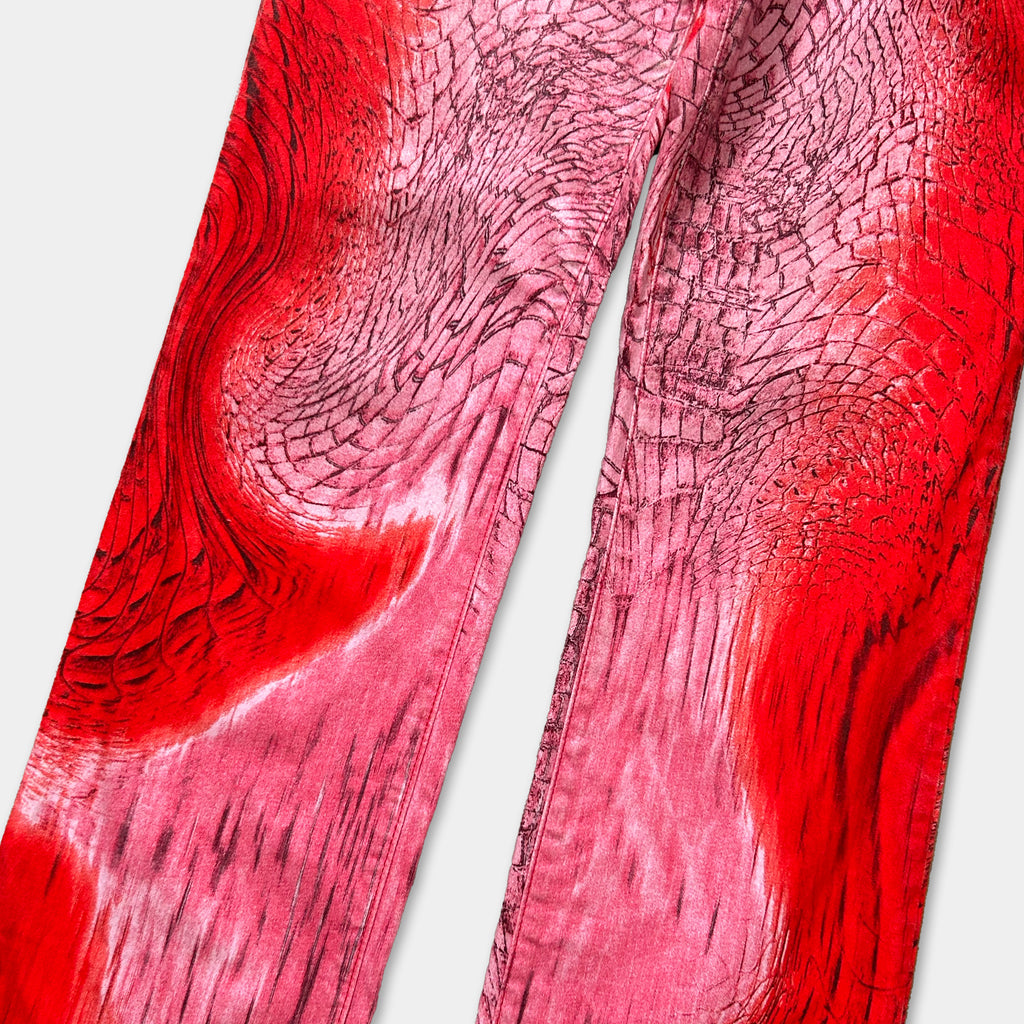 a pair of red pants with a unique, textured pattern that resembles a snake or a dragon. The pants appear to be made of a material with a bold, red color and a distinctive, abstract design.