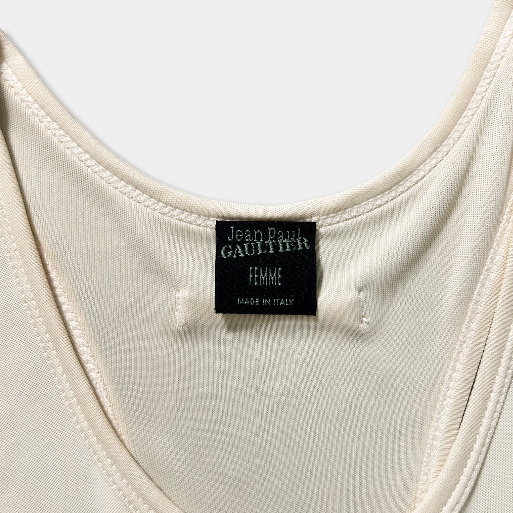 a close-up view of a white fabric, possibly a piece of clothing, with a label attached to it. The label appears to be a tag or label, possibly indicating the brand or manufacturer of the fabric.