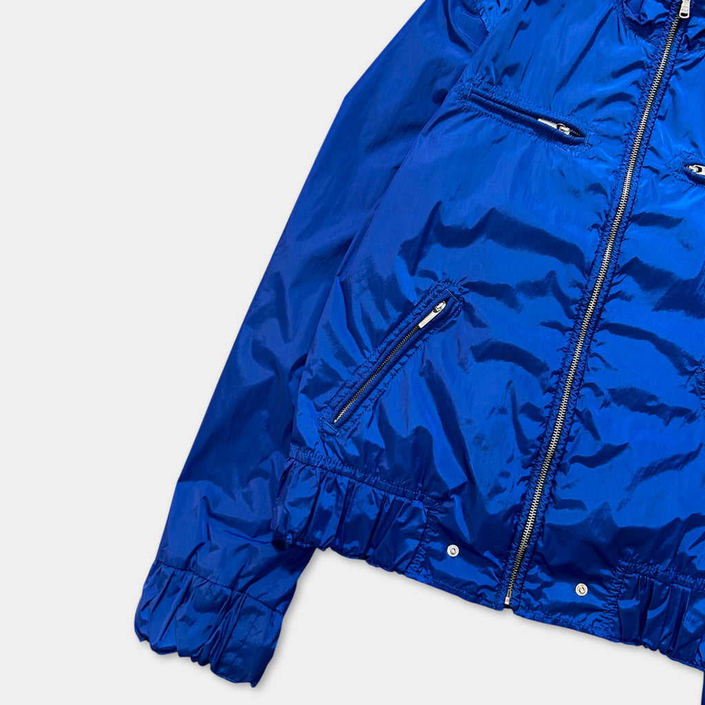 A bright blue jacket with a zipper and pockets, displayed on a white background.