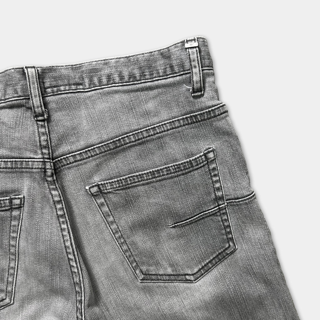 A close-up view of a pair of gray jeans, focusing on the pocket area.