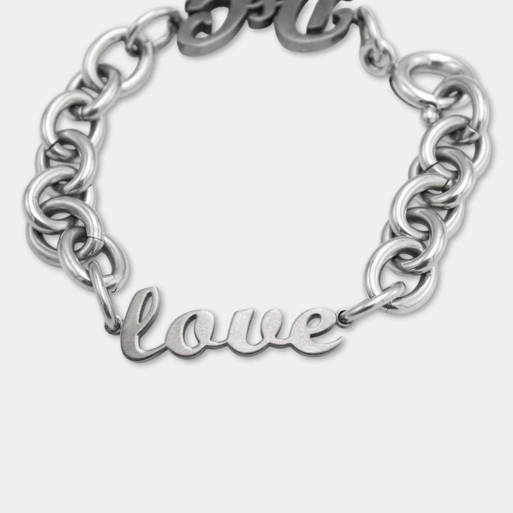 A silver-colored bracelet with the word "love" engraved on it.