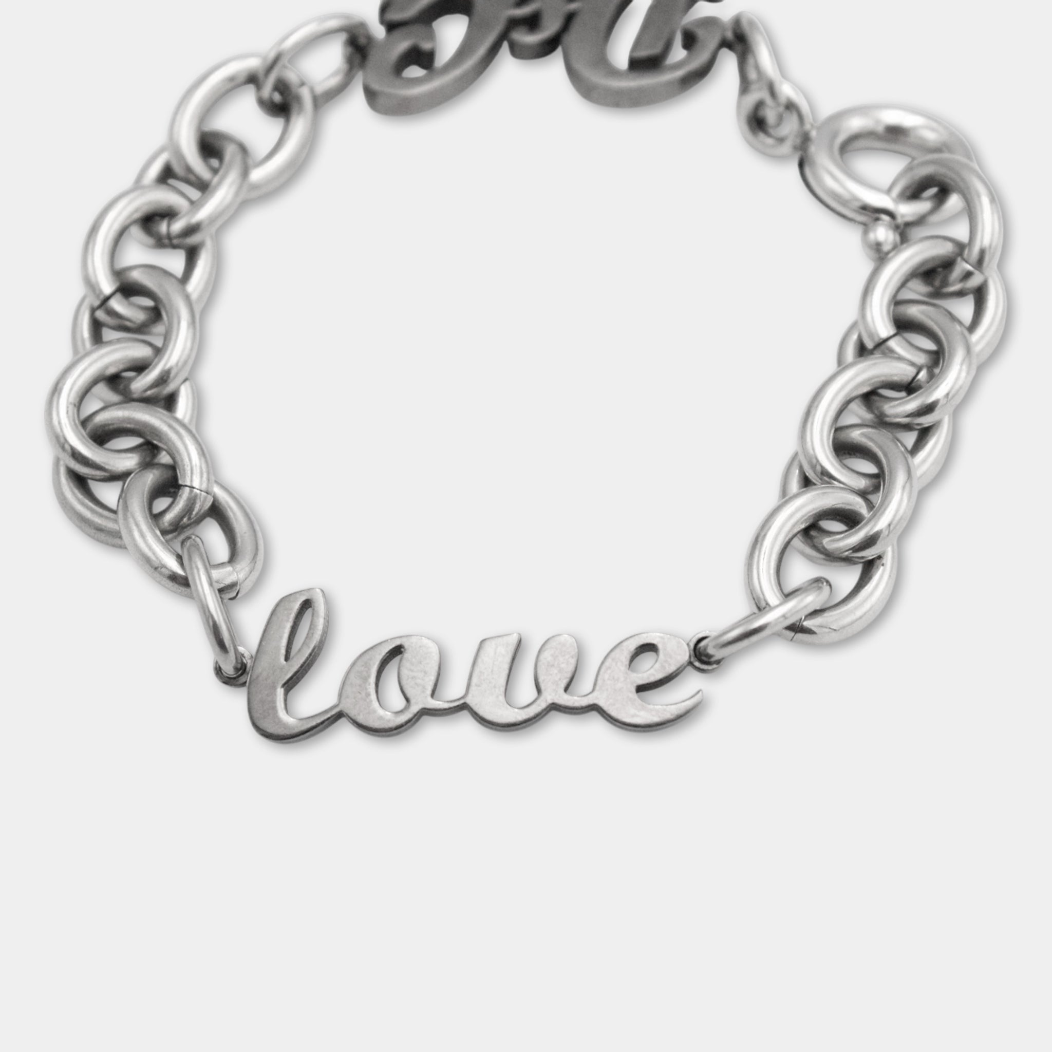A silver-colored bracelet with the word "love" engraved on it.