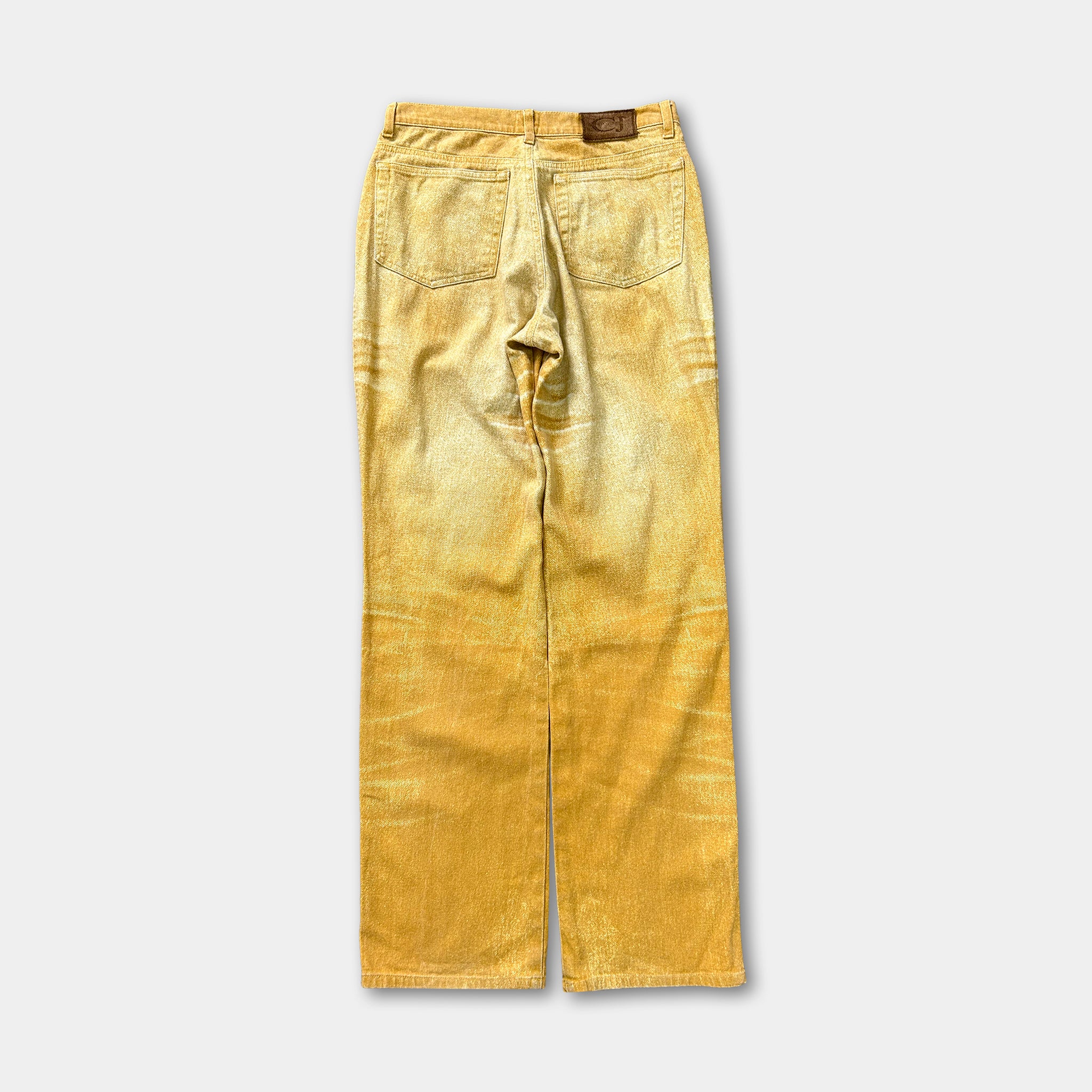 A pair of yellow-colored jeans with a faded, distressed appearance.