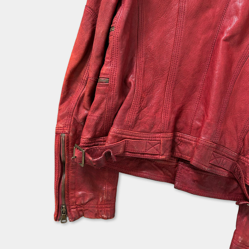 A close-up view of a red leather jacket with a zipper and belt detail.