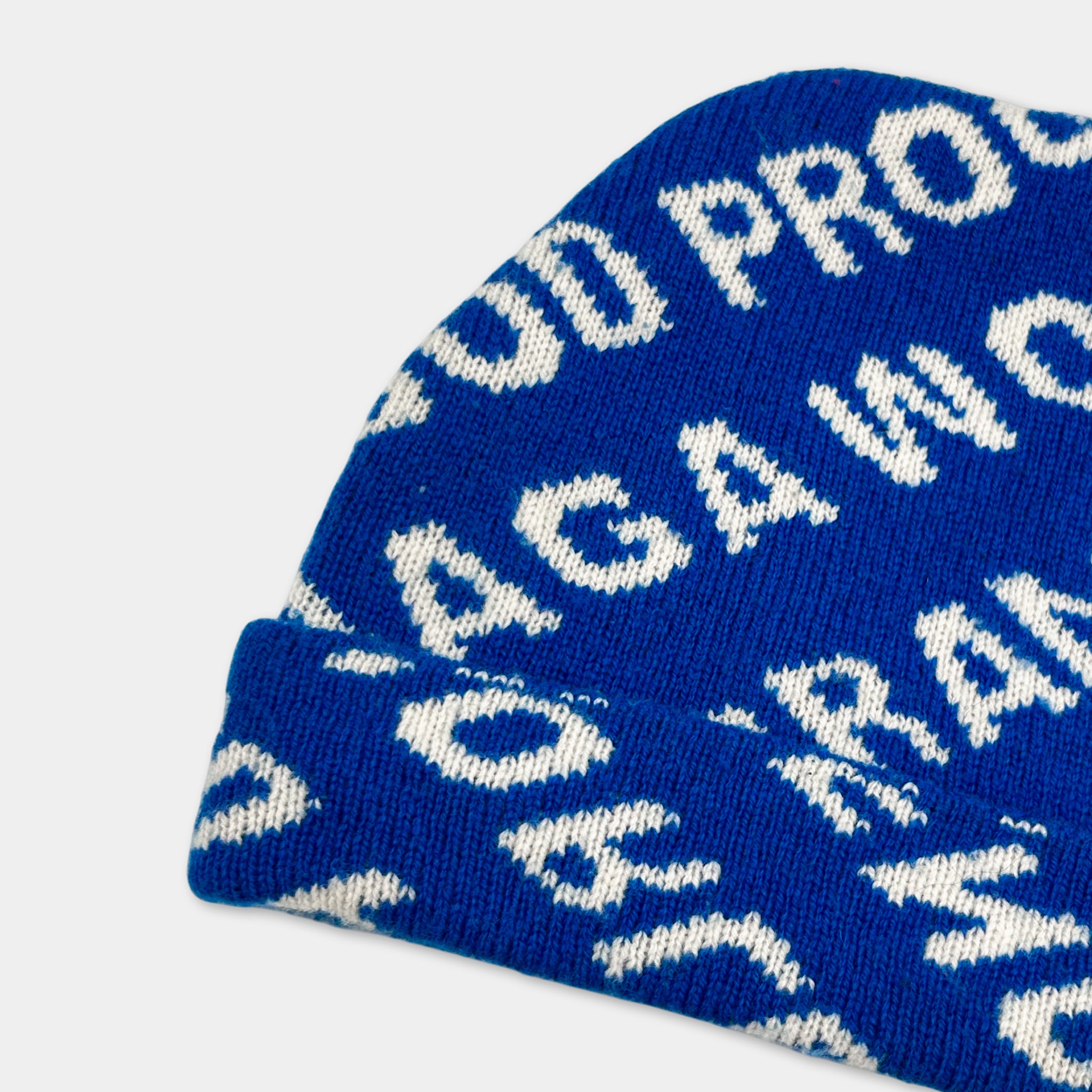 A blue knit beanie with white text printed on it.