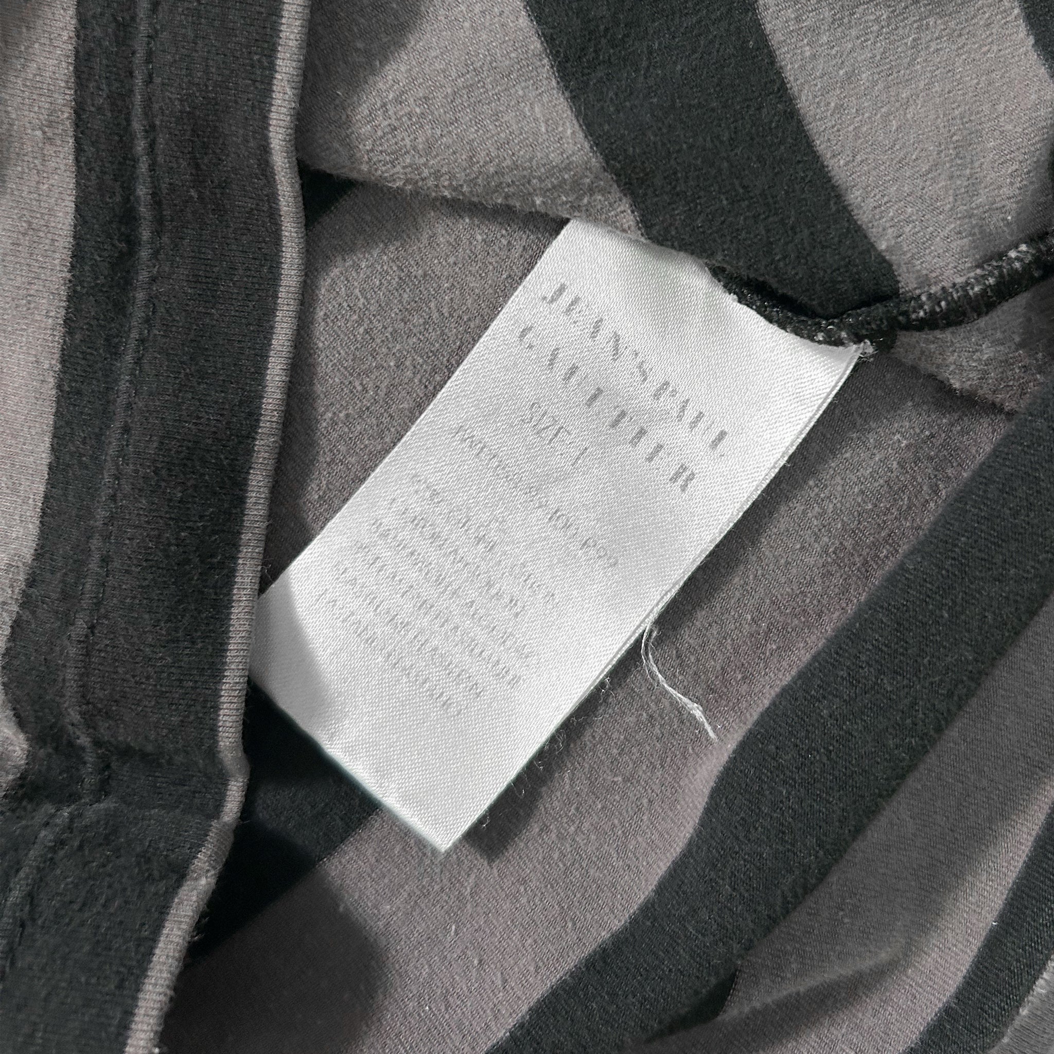 A close-up view of a fabric label with text, likely providing information about the clothing item.