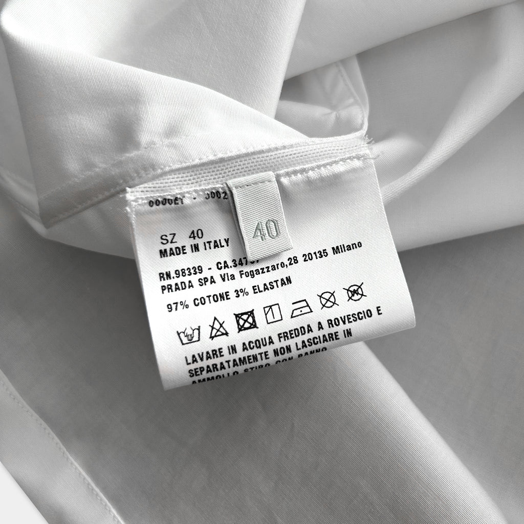 a close-up of a white fabric label with text and symbols, indicating the material and care instructions for the garment.