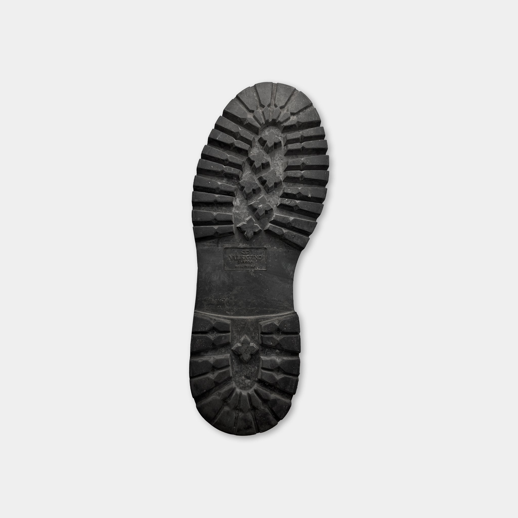 A black rubber sole of a shoe is shown against a white background.
