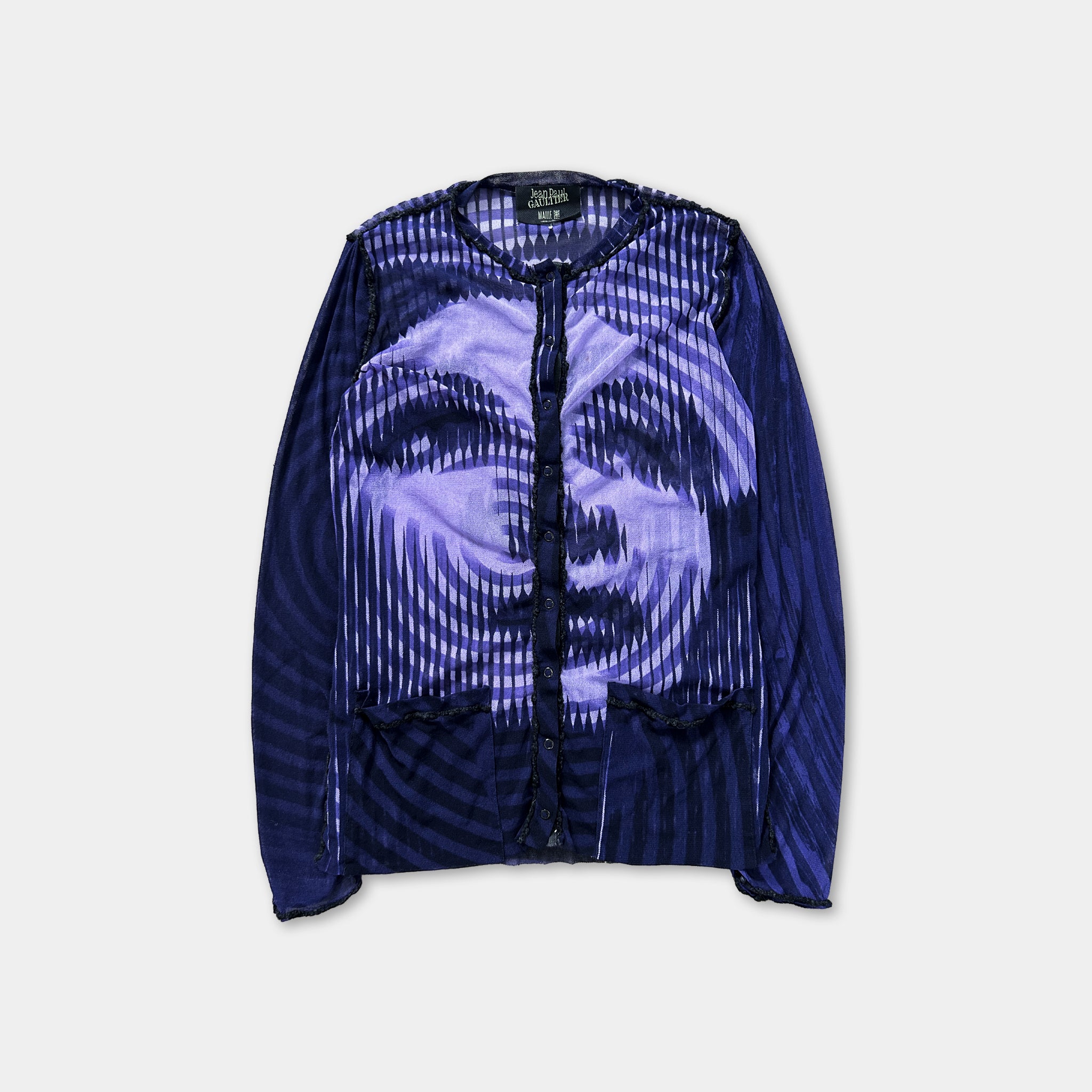 a blue and purple patterned long-sleeved top or cardigan with a striking face design.
