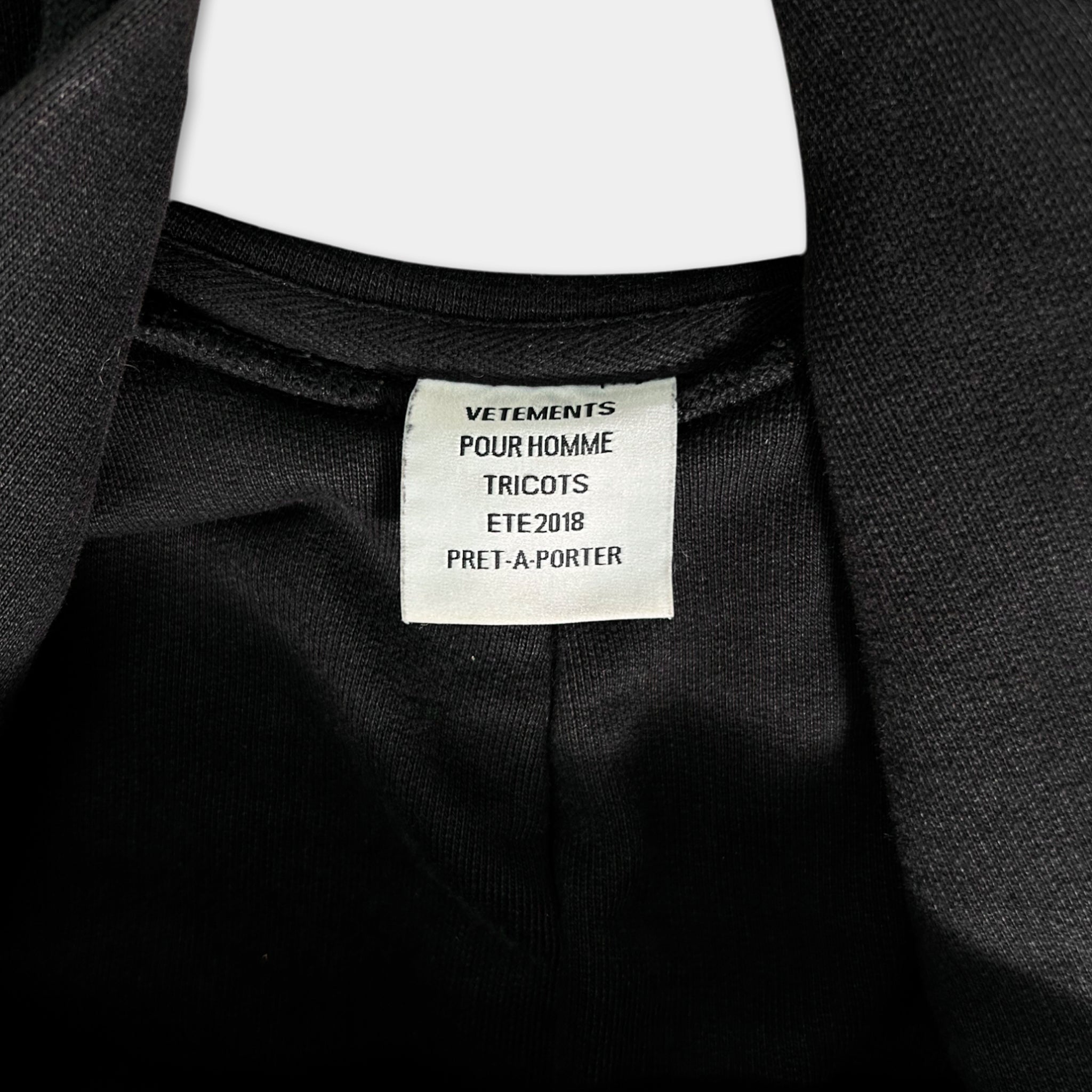 a close-up view of a black jacket with a label attached to it.