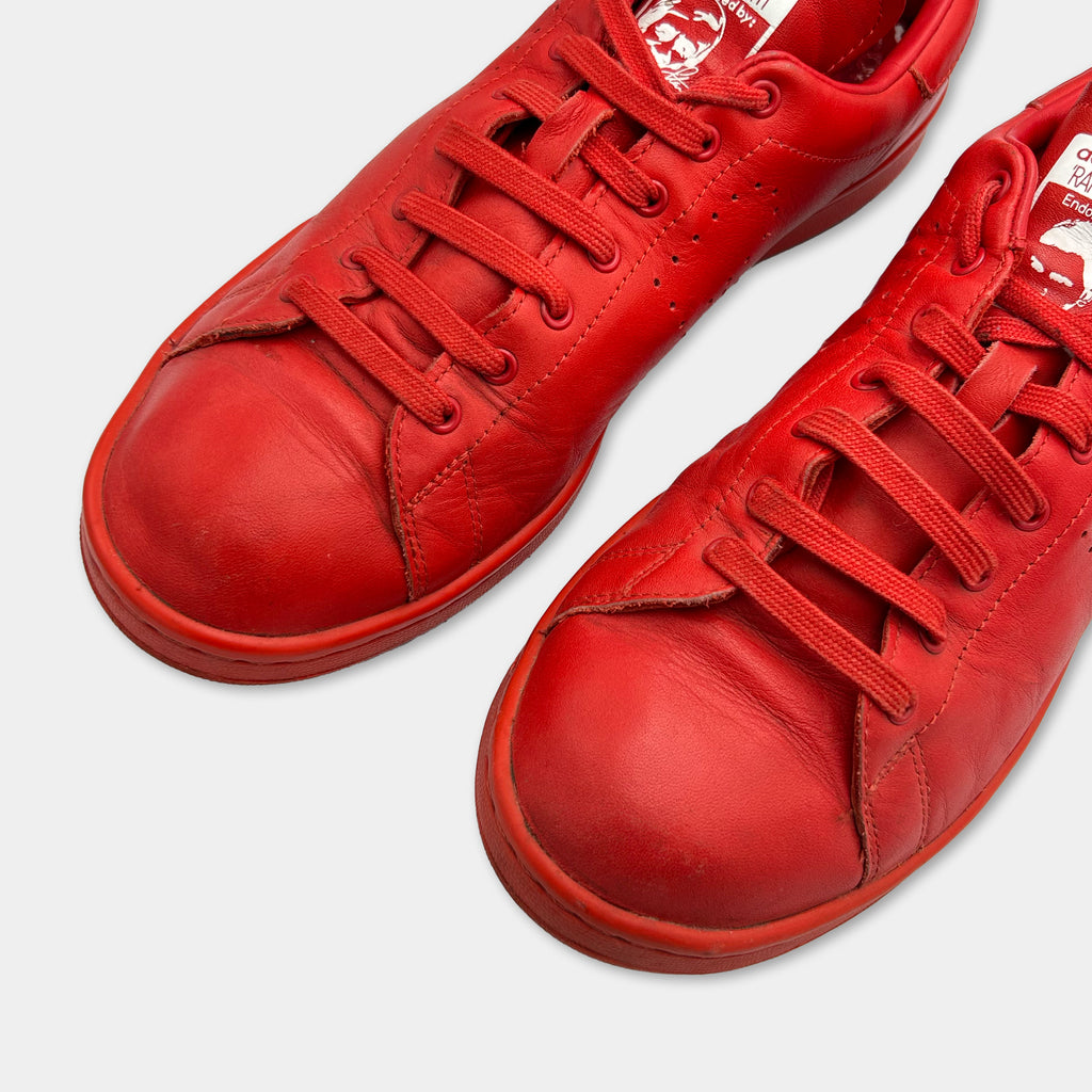 A pair of red leather sneakers with red laces and soles.