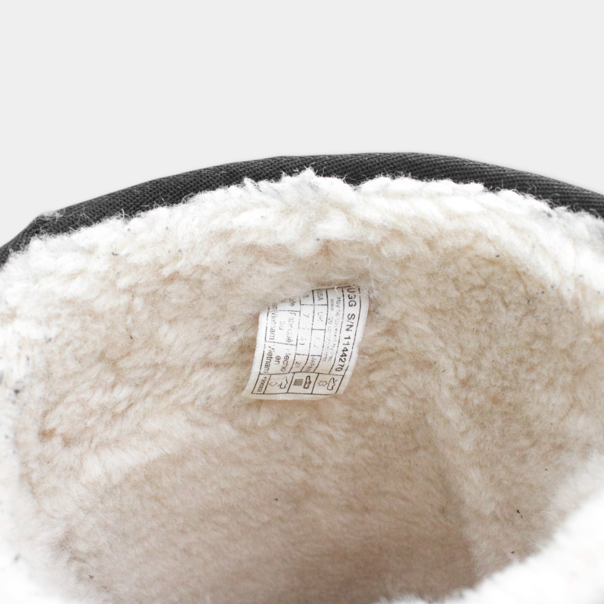 the inside of a pair of boots, with a label attached to the lining.
