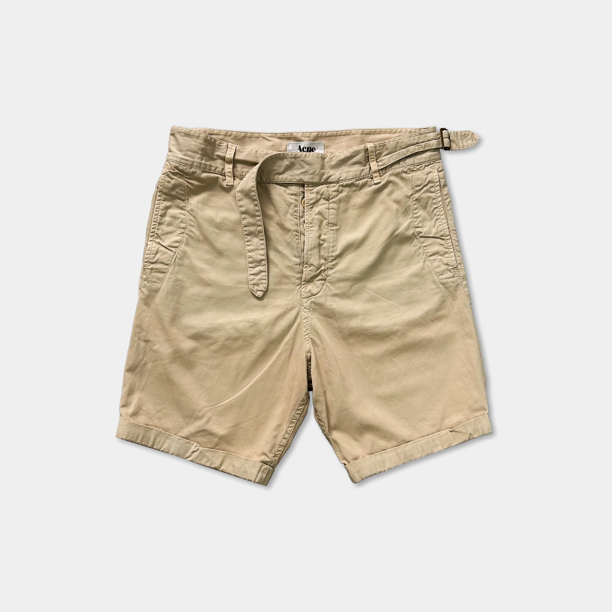 A pair of khaki cargo shorts with a belt.