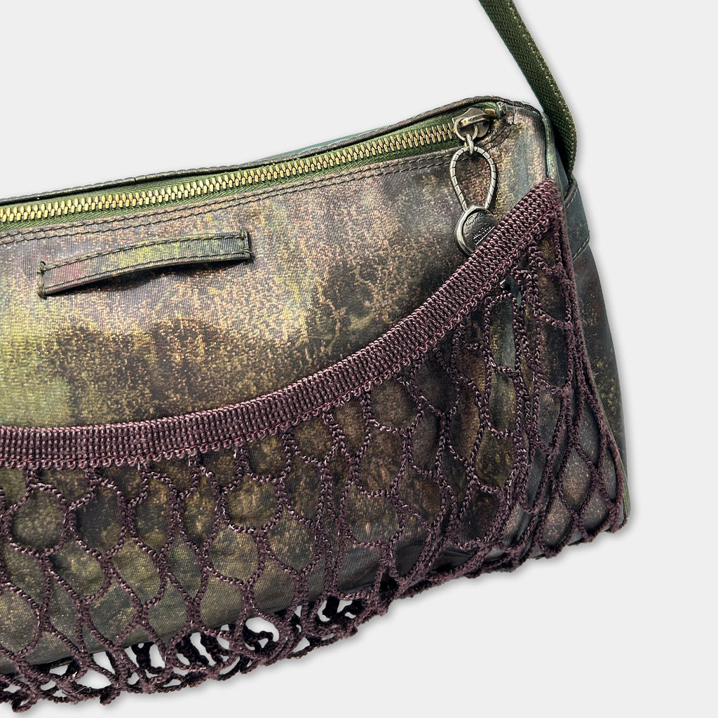 A close-up view of a handbag with a mesh pocket and a zipper closure.
