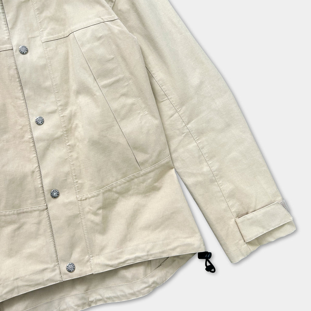 A beige jacket with buttons and a zipper, featuring a casual and relaxed style.