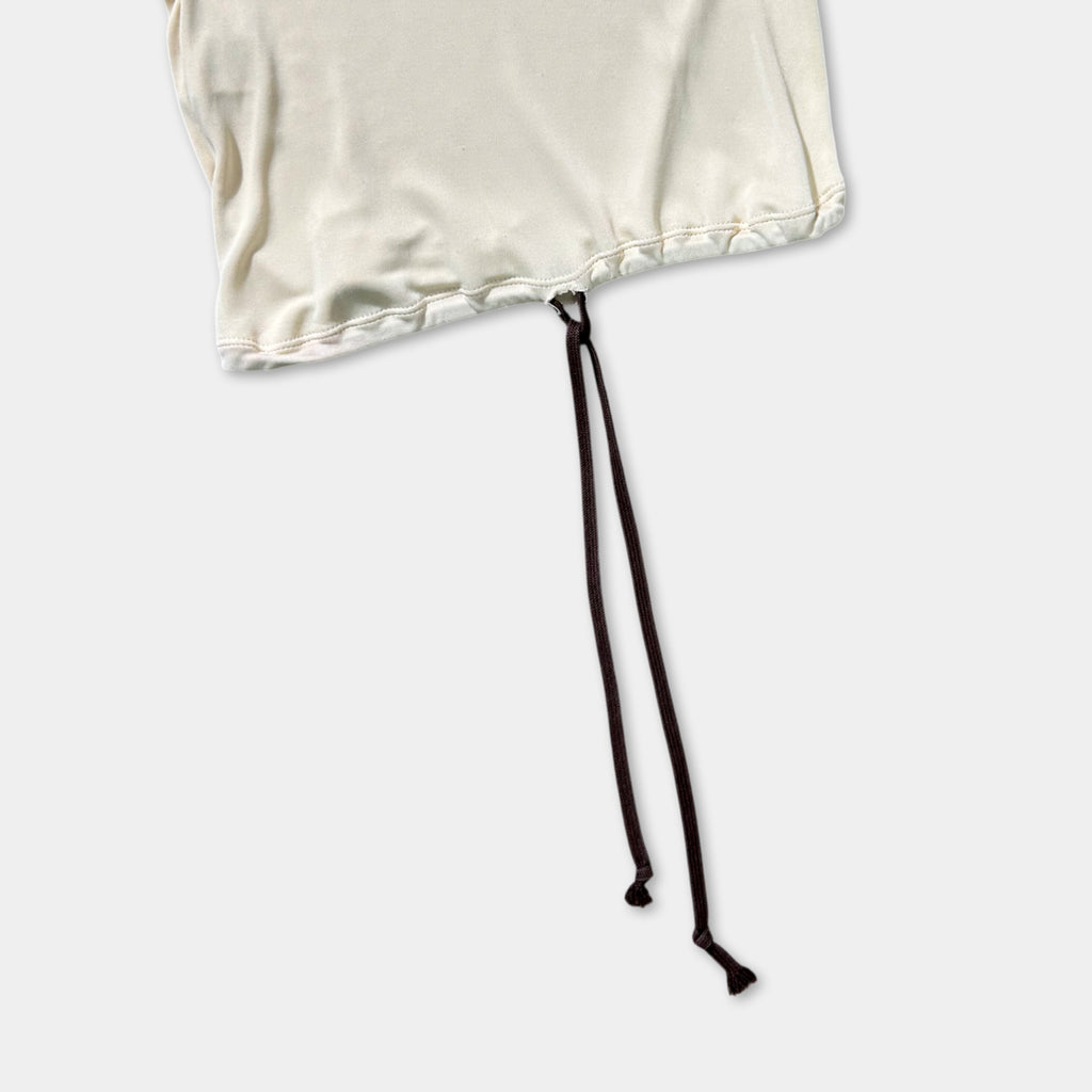 A white fabric with a black drawstring or tie attached to it, lying on a plain white background.