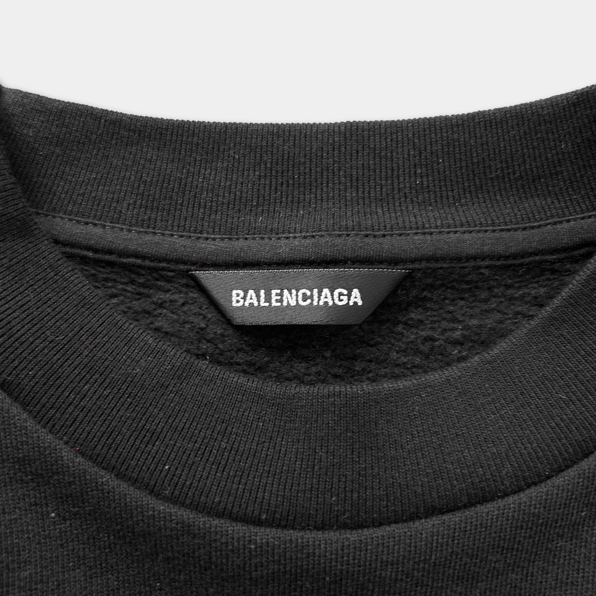 A close-up view of a black sweater with a label that reads "BALENCIA" on it.
