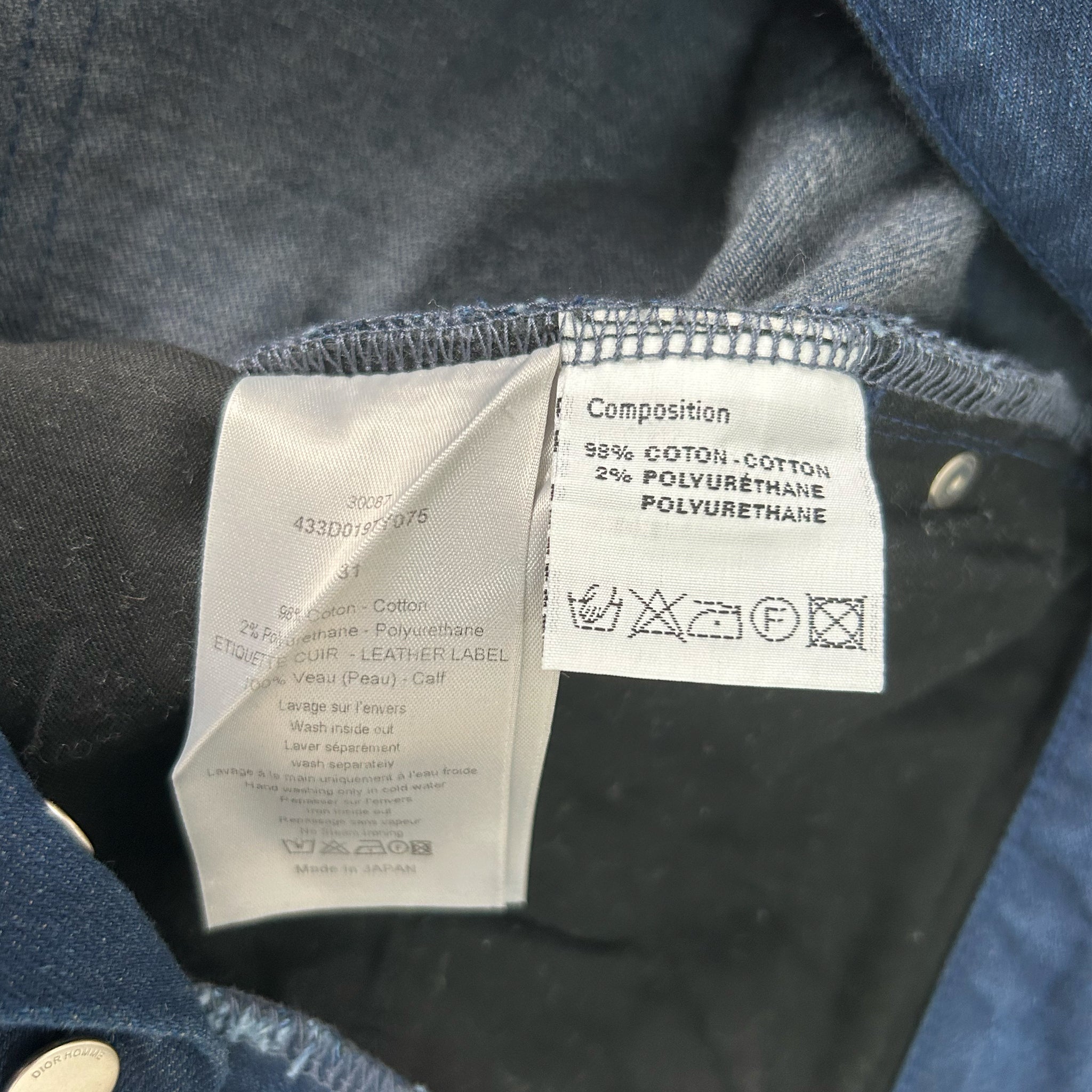 a close-up view of a clothing label, specifically a denim shirt, with details about the fabric composition and care instructions.