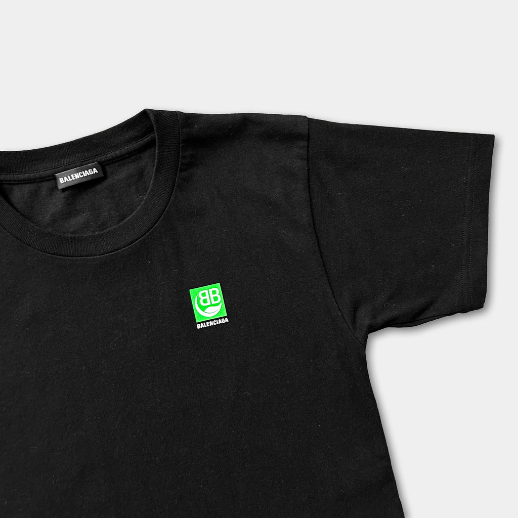 A black t-shirt with a green logo on the left side.