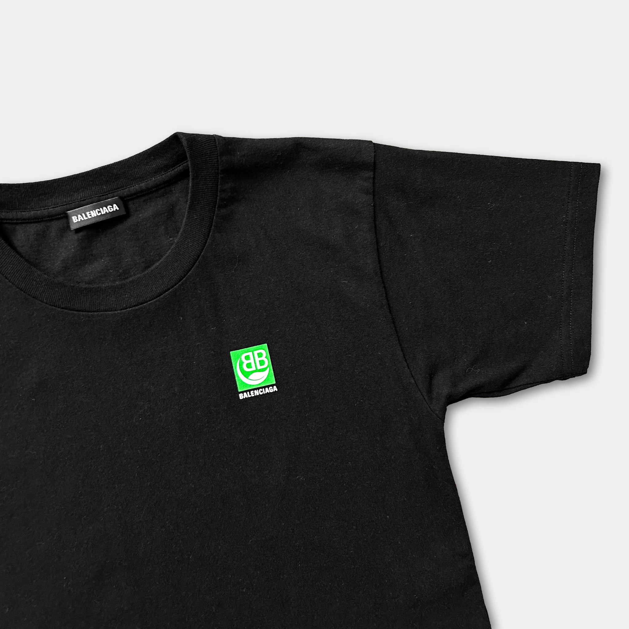 A black t-shirt with a green logo on the left side.