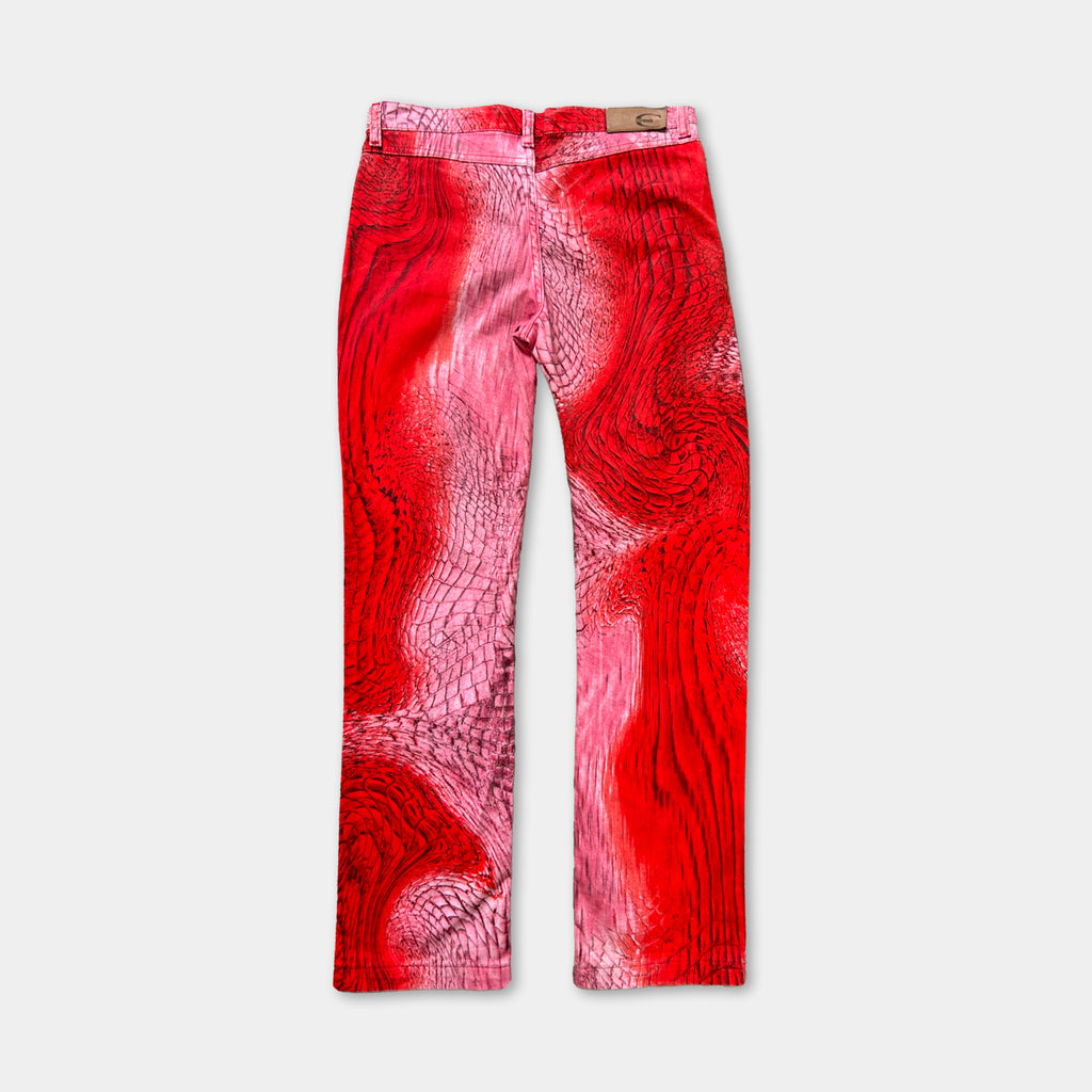 A pair of red pants with a unique, abstract pattern on the fabric.
