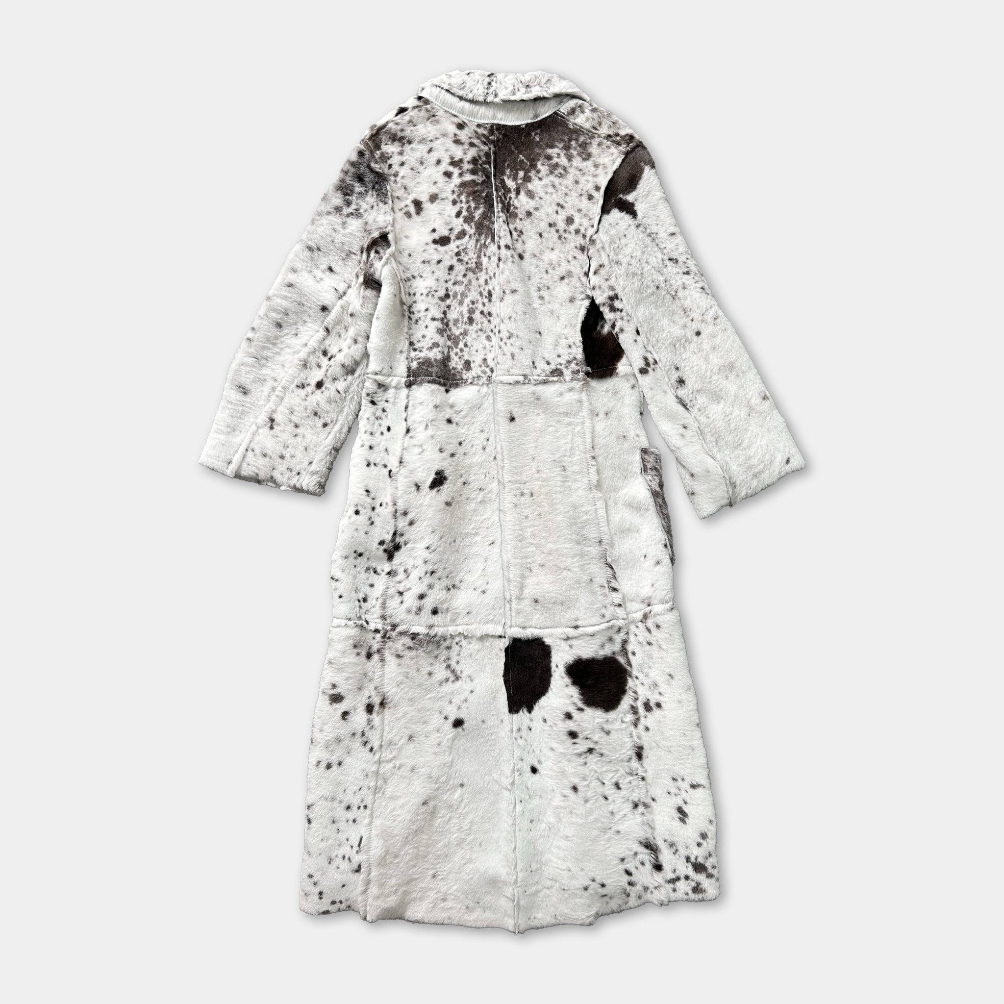 a long, white coat with a distinctive black and white spotted pattern.