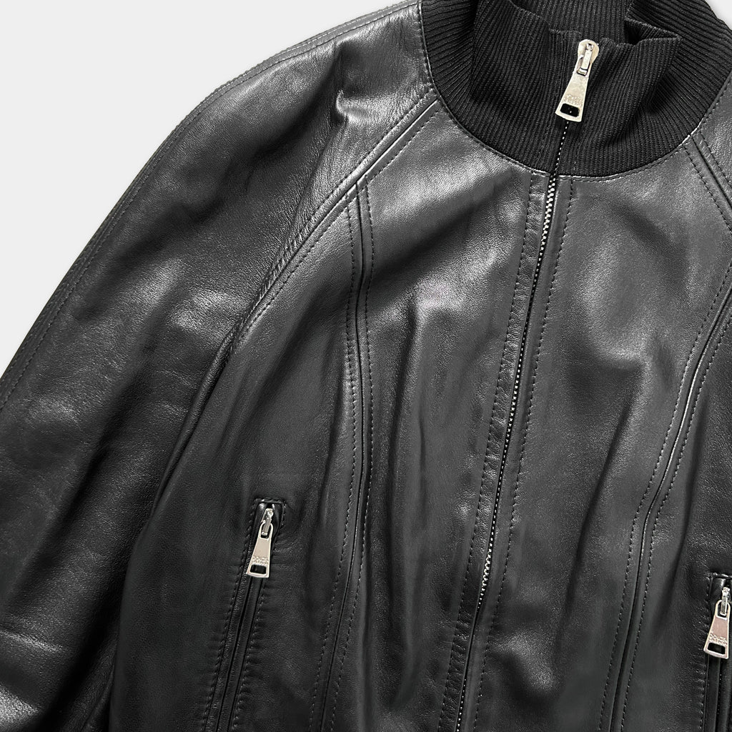 A close-up view of a black leather jacket with a zipper and a collar.