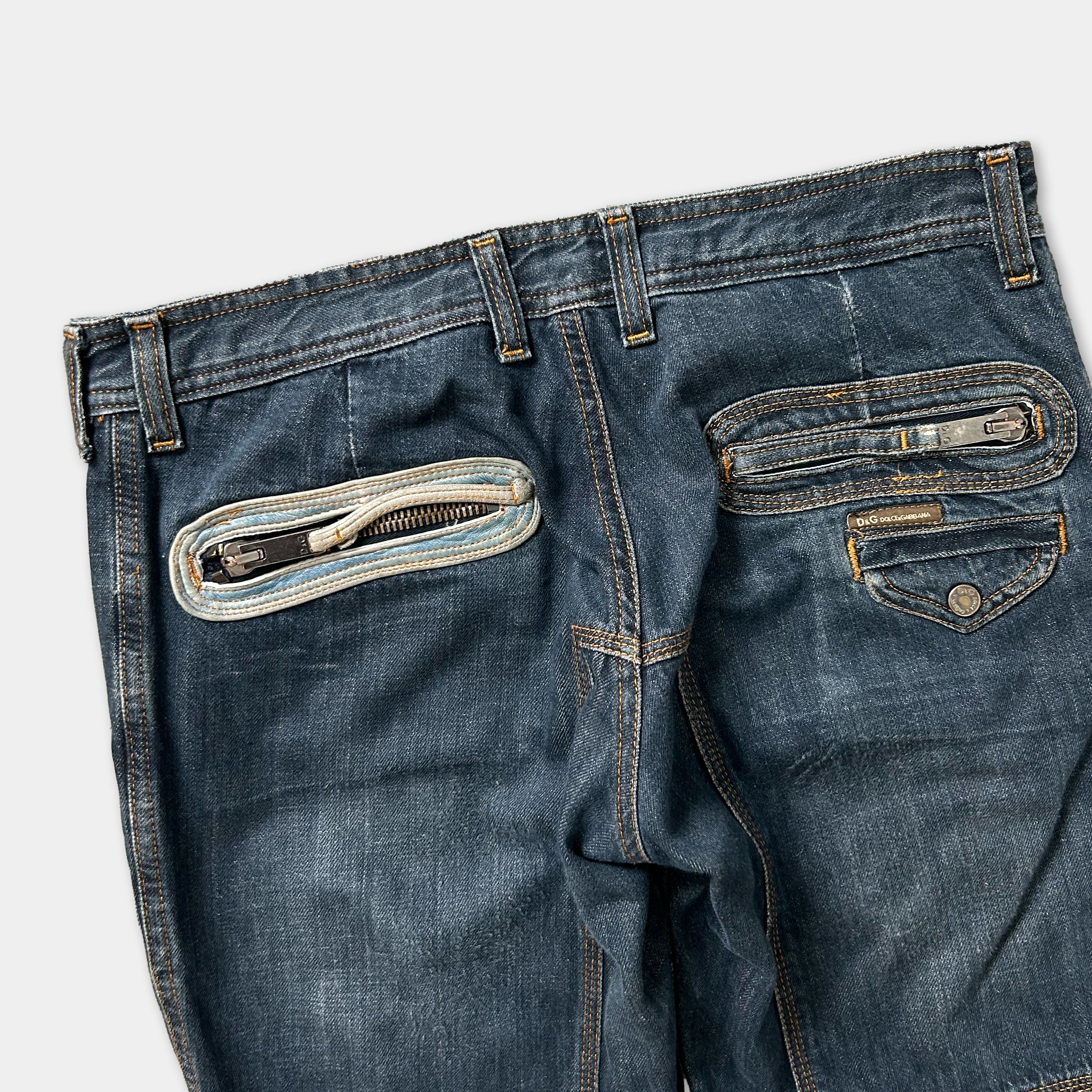 A pair of blue jeans with a zipper pocket and a zipper pull visible.