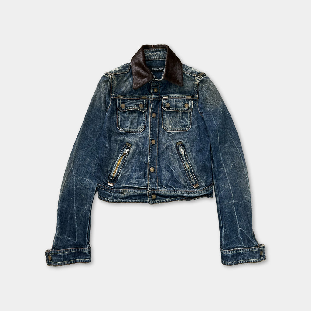 A blue denim jacket with a brown collar and zipper pockets is displayed against a white background.