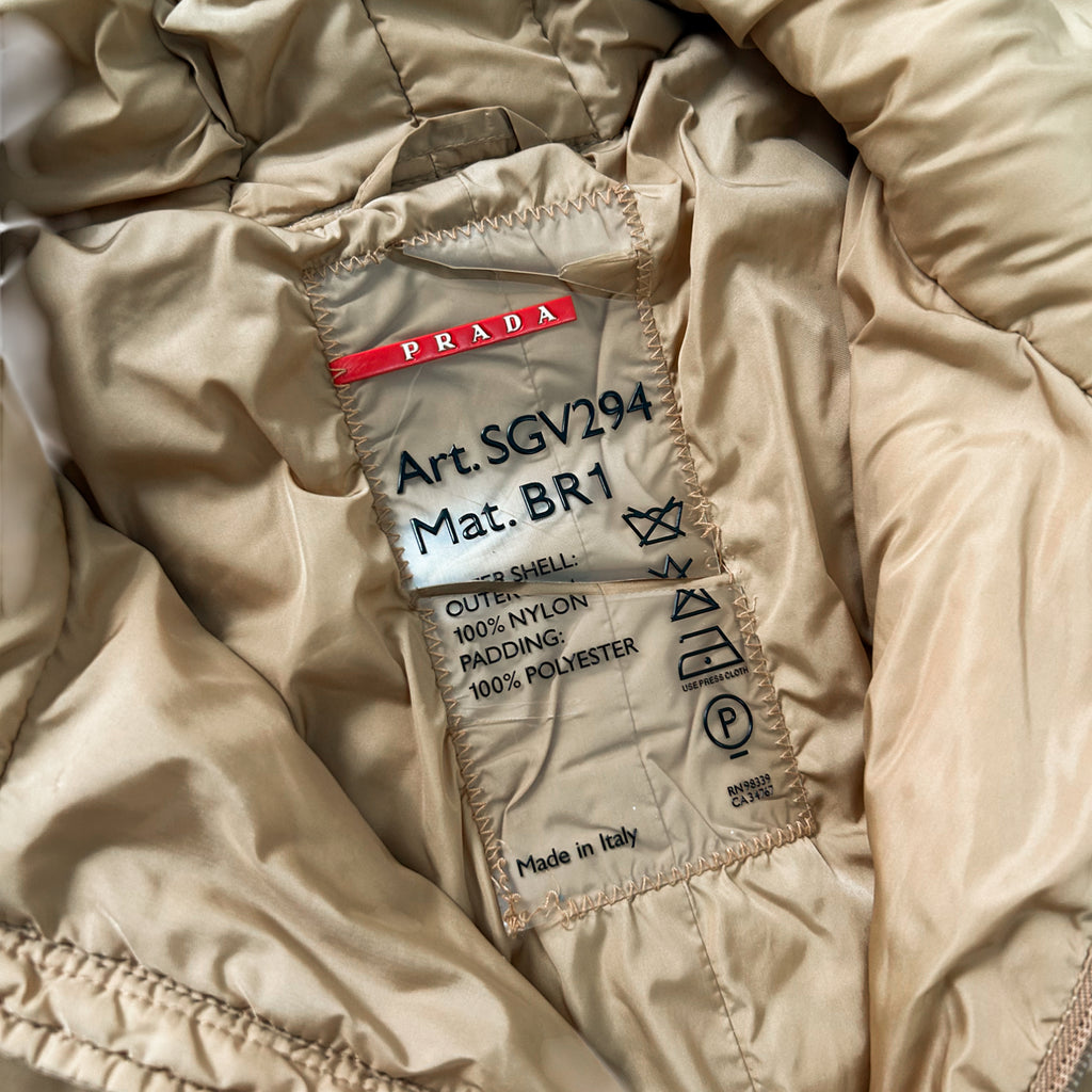 a close-up view of a Prada jacket label, which is a transparent label with text and symbols indicating the material and manufacturing details of the jacket.