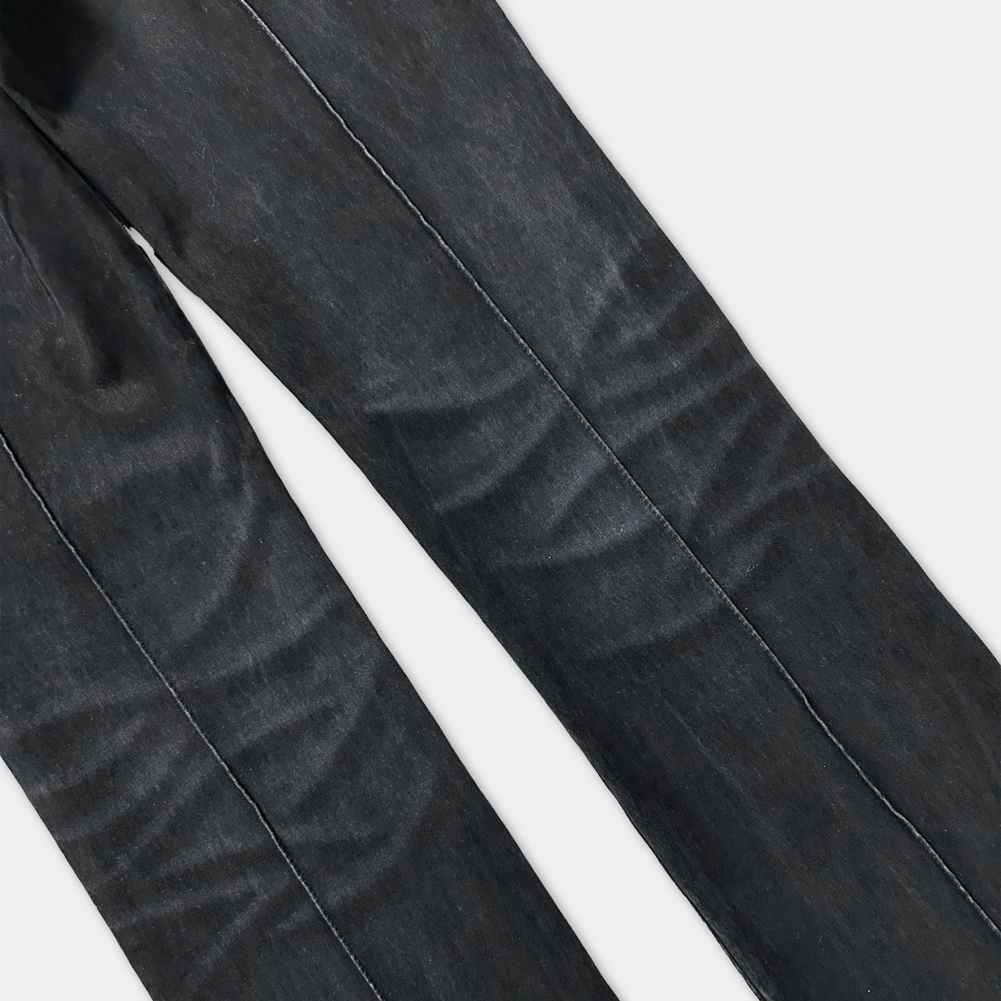 A close-up view of a pair of black jeans, showing the fabric and stitching.