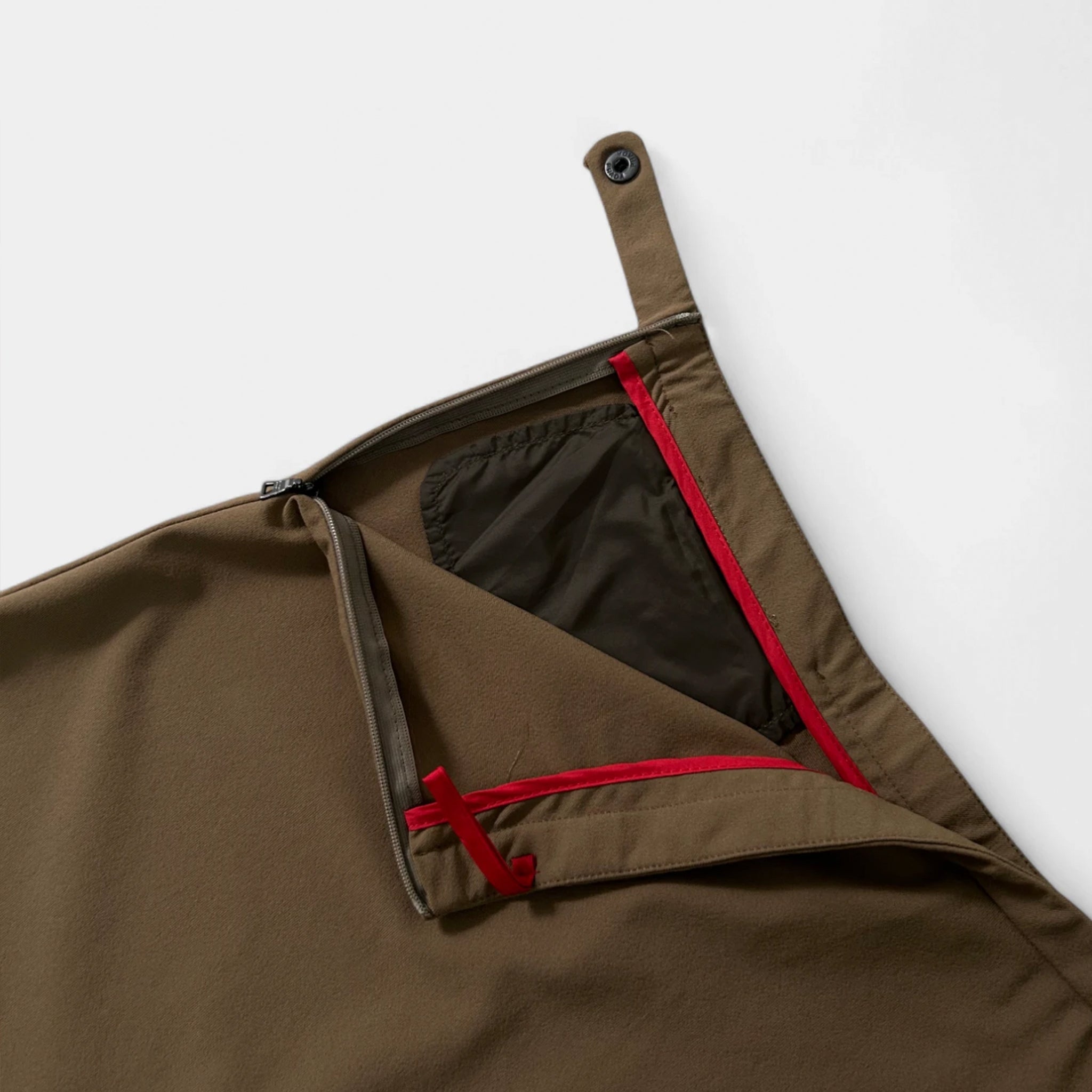 A brown garment with a red zipper and a black pocket is shown in the image.