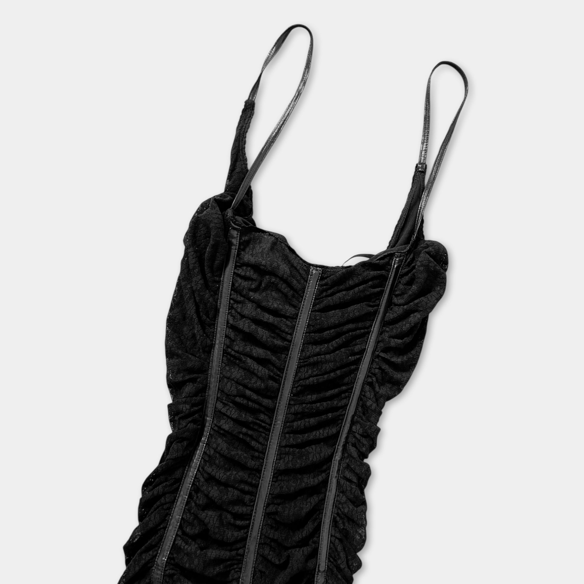 A black, ruched dress with straps is shown against a white background.